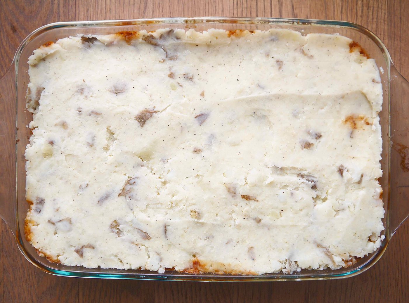 The cauliflower and potato mash spread out on to of the beef gravy.