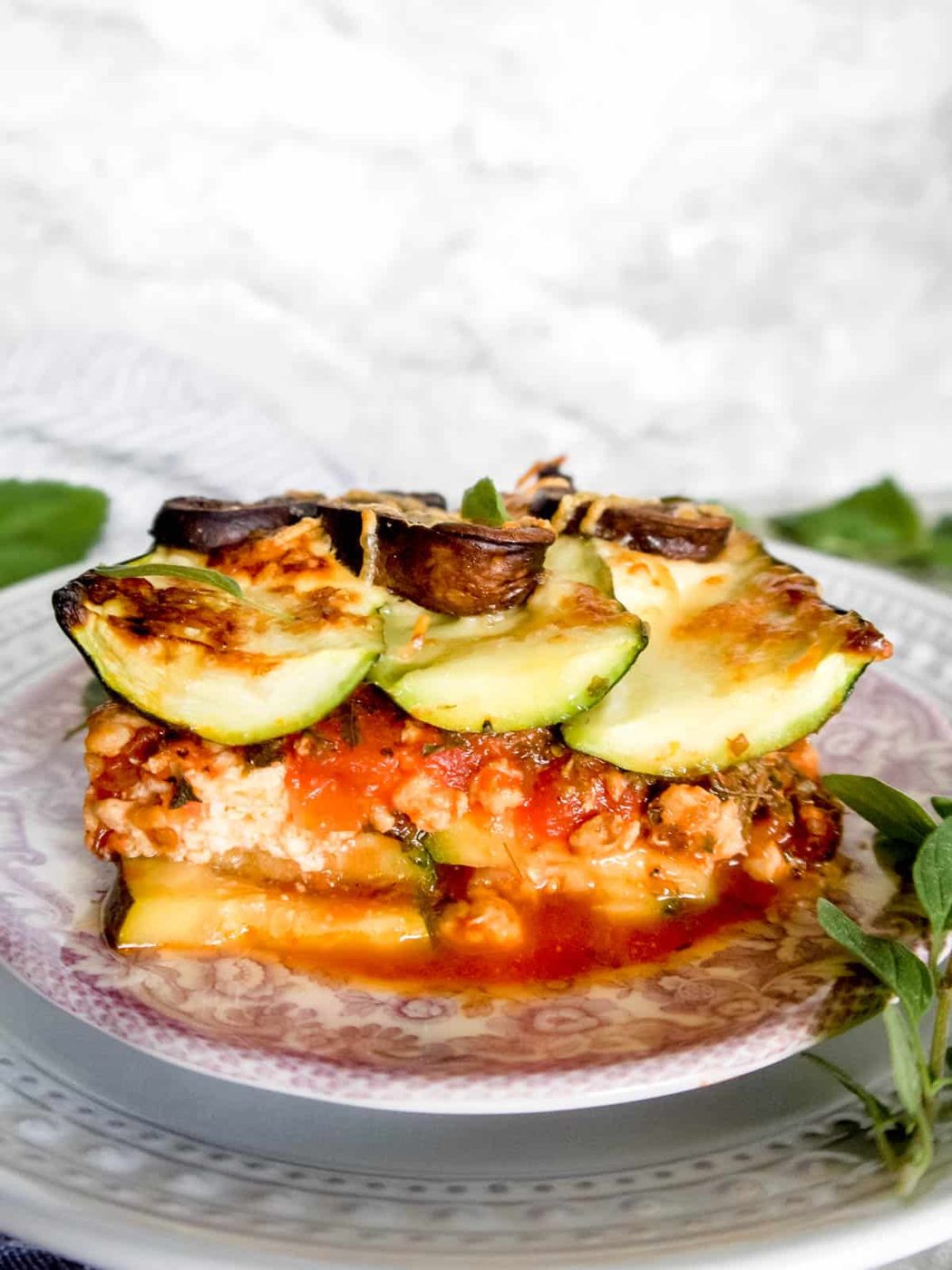 Side angle of zucchini mushroom lasagna on a plate.
