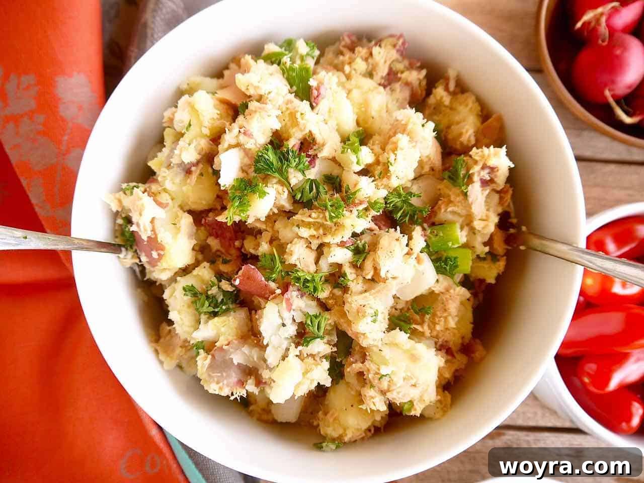 Paleo Whole30 French Tuna Potato Salad 2 A large bowl of healthy French tuna potato salad, showcasing a vibrant mix of potatoes, tuna, and fresh herbs.