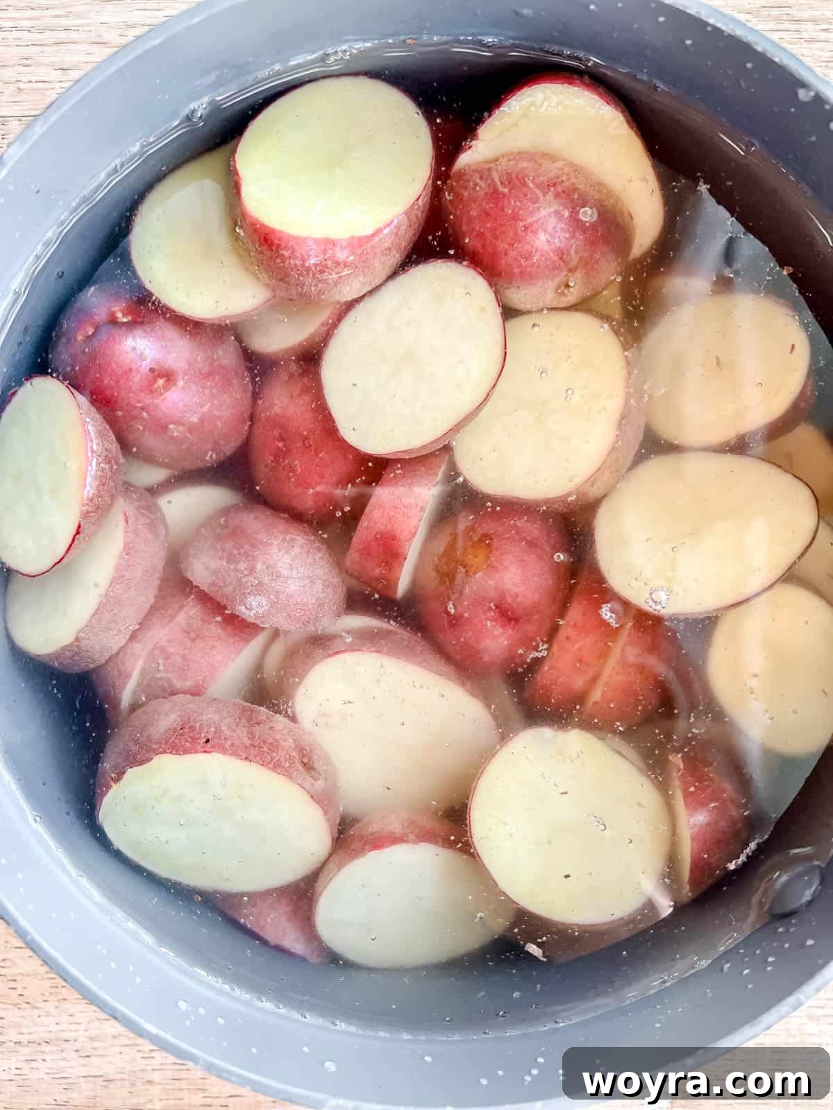 Paleo Whole30 French Tuna Potato Salad 4 Sliced red potatoes in a pan of boiling water, ready for cooking.