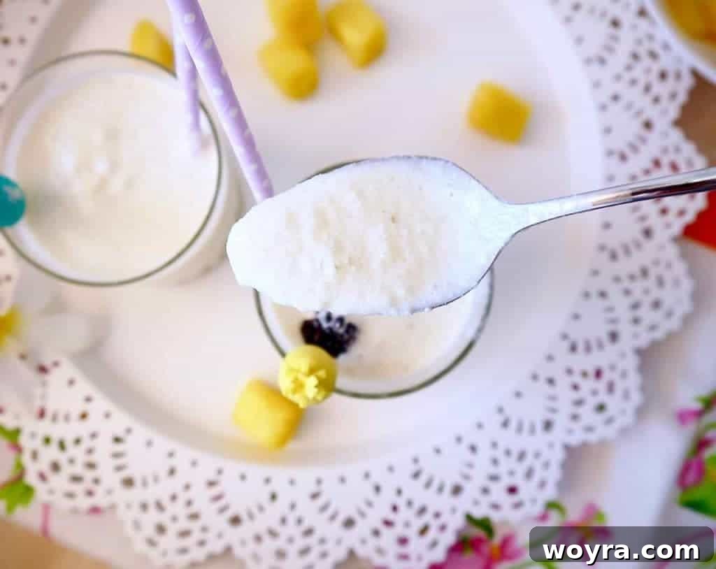 Guilt Free Paleo Pina Coladas 7 An overhead shot of a single glass of All Natural Piña Colada with a straw, emphasizing its inviting and refreshing qualities.