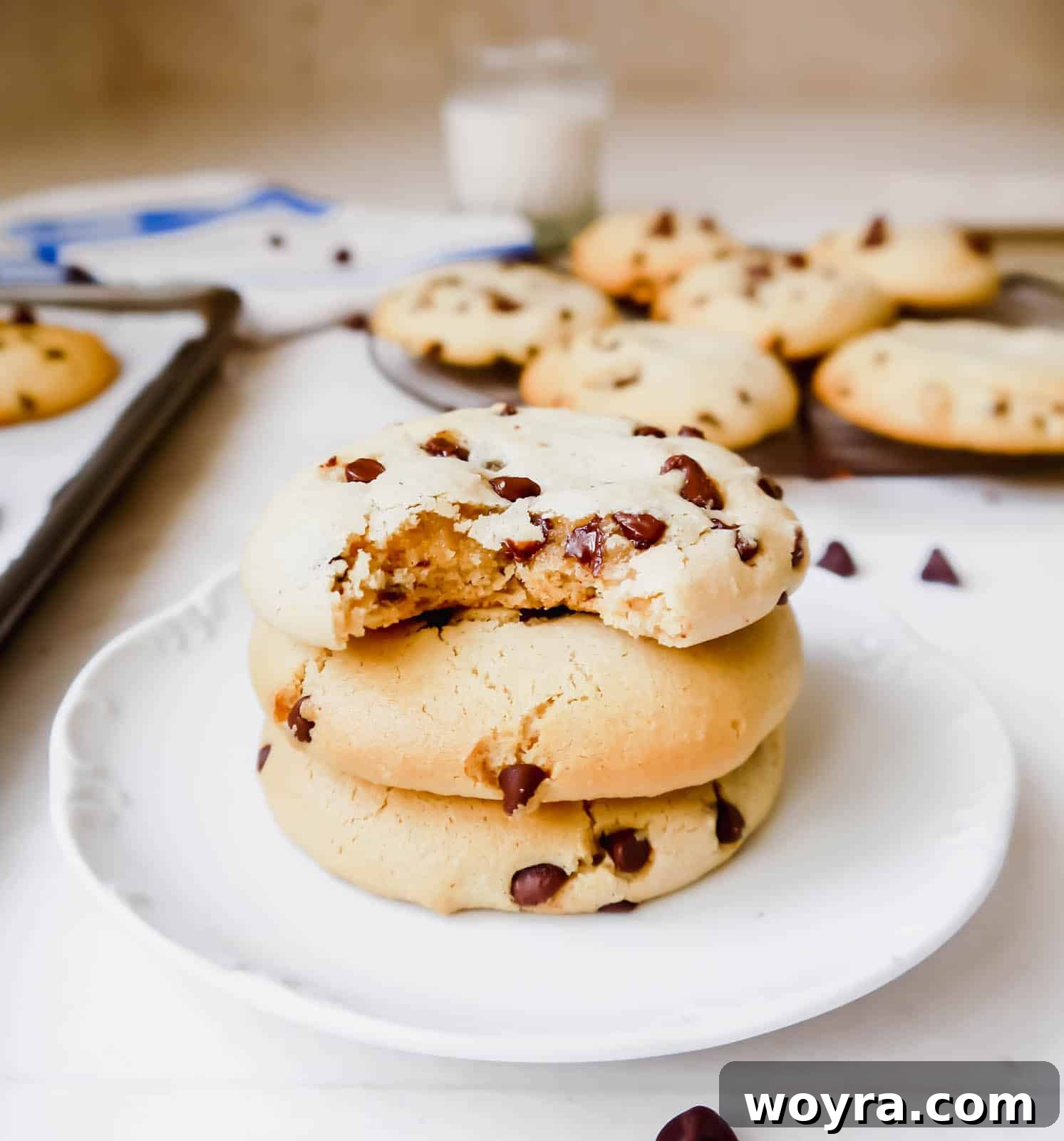 A stack of soft tapioca flour chocolate chip cookies, with the top cookie having a bite taken out, showing its tender crumb and rich chocolate.