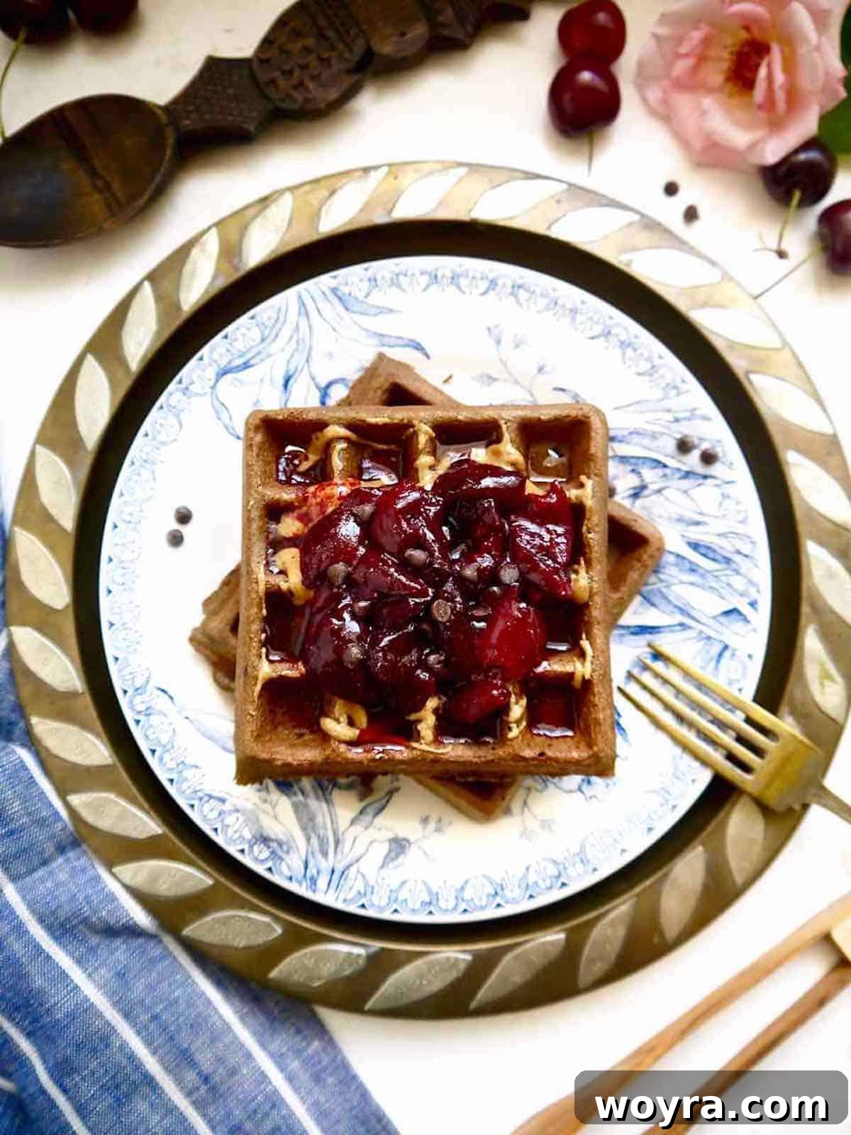 Indulgent Paleo Chocolate Cherry Waffles 3 Two gluten-free chocolate waffles with generous cherry compote on top, showcasing the vibrant fruit and rich waffle texture.