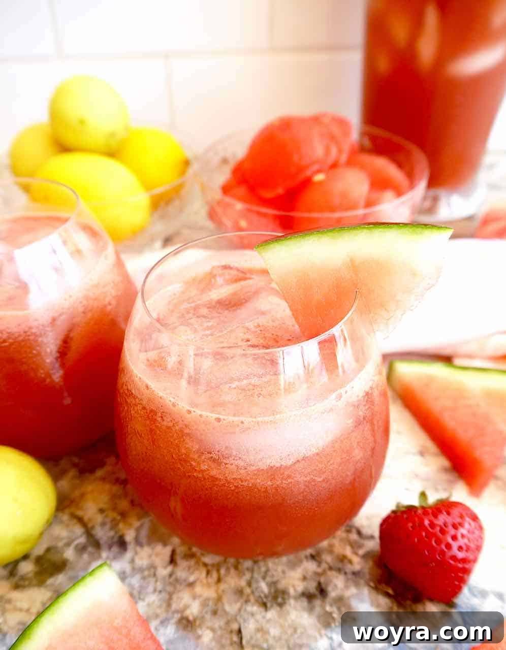 Strawberry Watermelon Cucumber Cooler 2 Two glasses of refreshing strawberry watermelon cucumber juice garnished with a slice of cucumber and a strawberry.