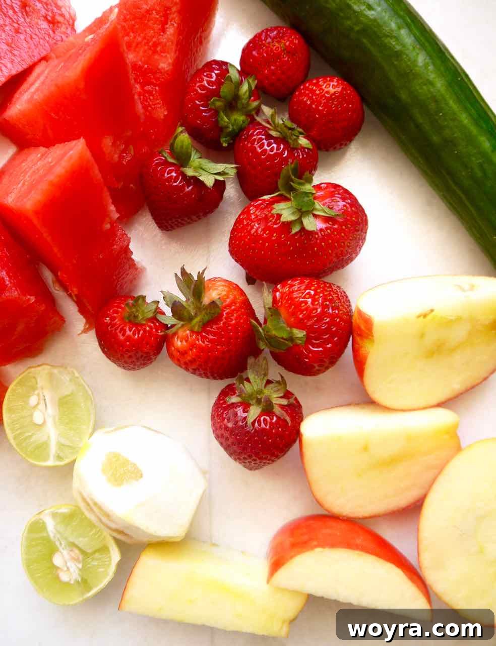 Strawberry Watermelon Cucumber Cooler 3 Fresh ingredients including watermelon, strawberries, cucumber, apple, lemon, and lime laid out for juicing.