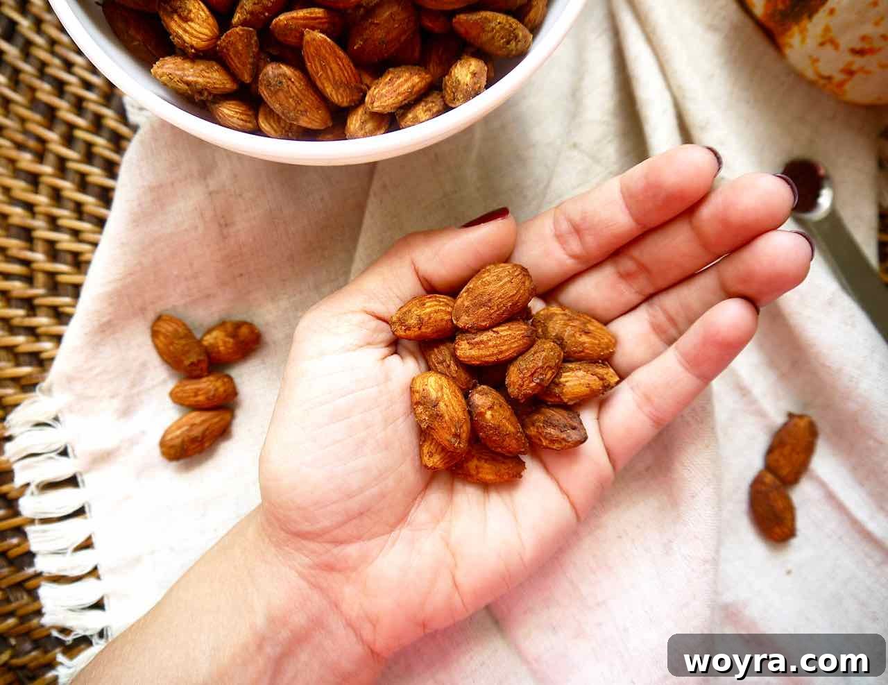 Toasted Pumpkin Spice Almonds 3 A hand holding a small pile of roasted pumpkin spice almonds, showing their texture.