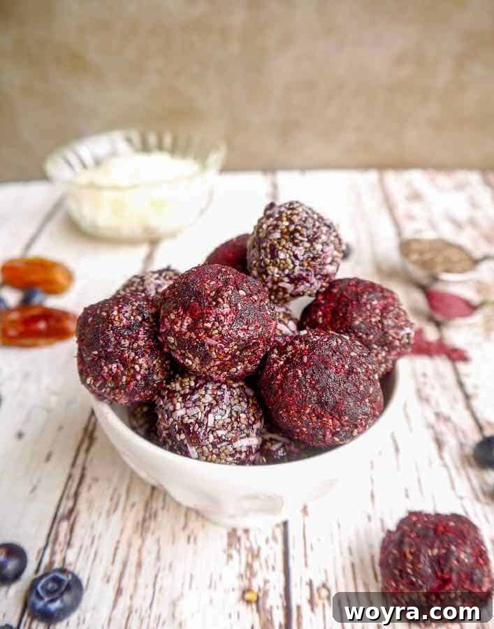 Paleo Vegan Blueberry Date Power Bites 5 Hand holding a Blueberry Date Energy Ball.