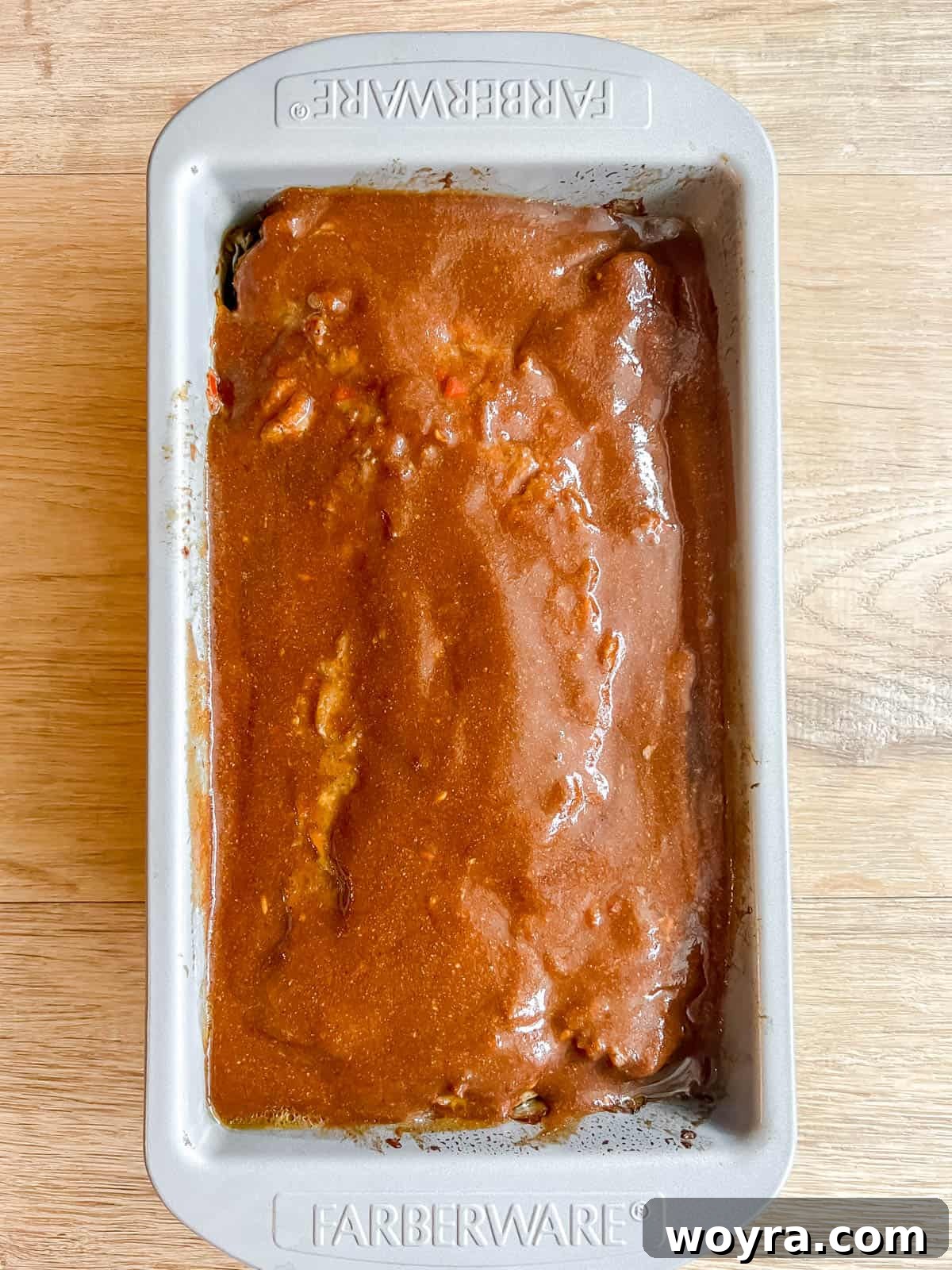 Clean Paleo Meatloaf 10 Paleo meatloaf in a loaf tin with a layer of sauce on top.