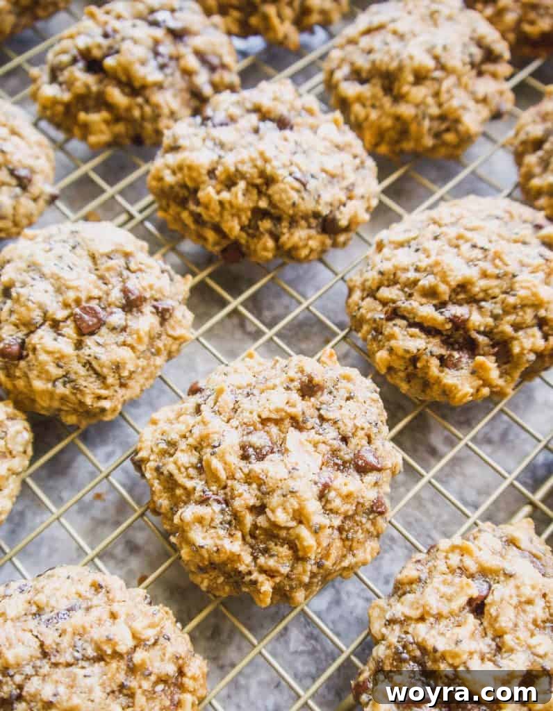 Wholesome Gluten Free Chia Oatmeal Cookies 5 A hand reaching for a Gluten-Free Chia Oatmeal Cookie from a cooling rack.
