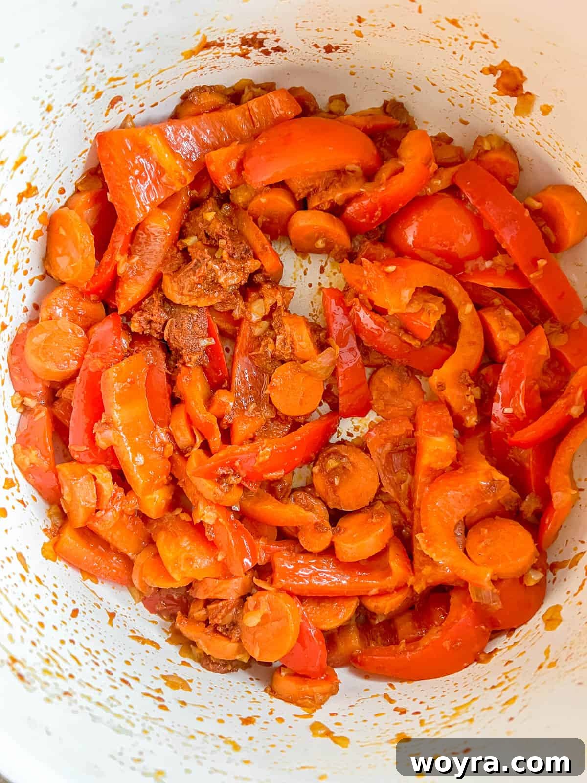Plant-Based Paleo Thai Red Curry 6 Red curry paste and fresh ginger are stirred into the vegetables in the pan.