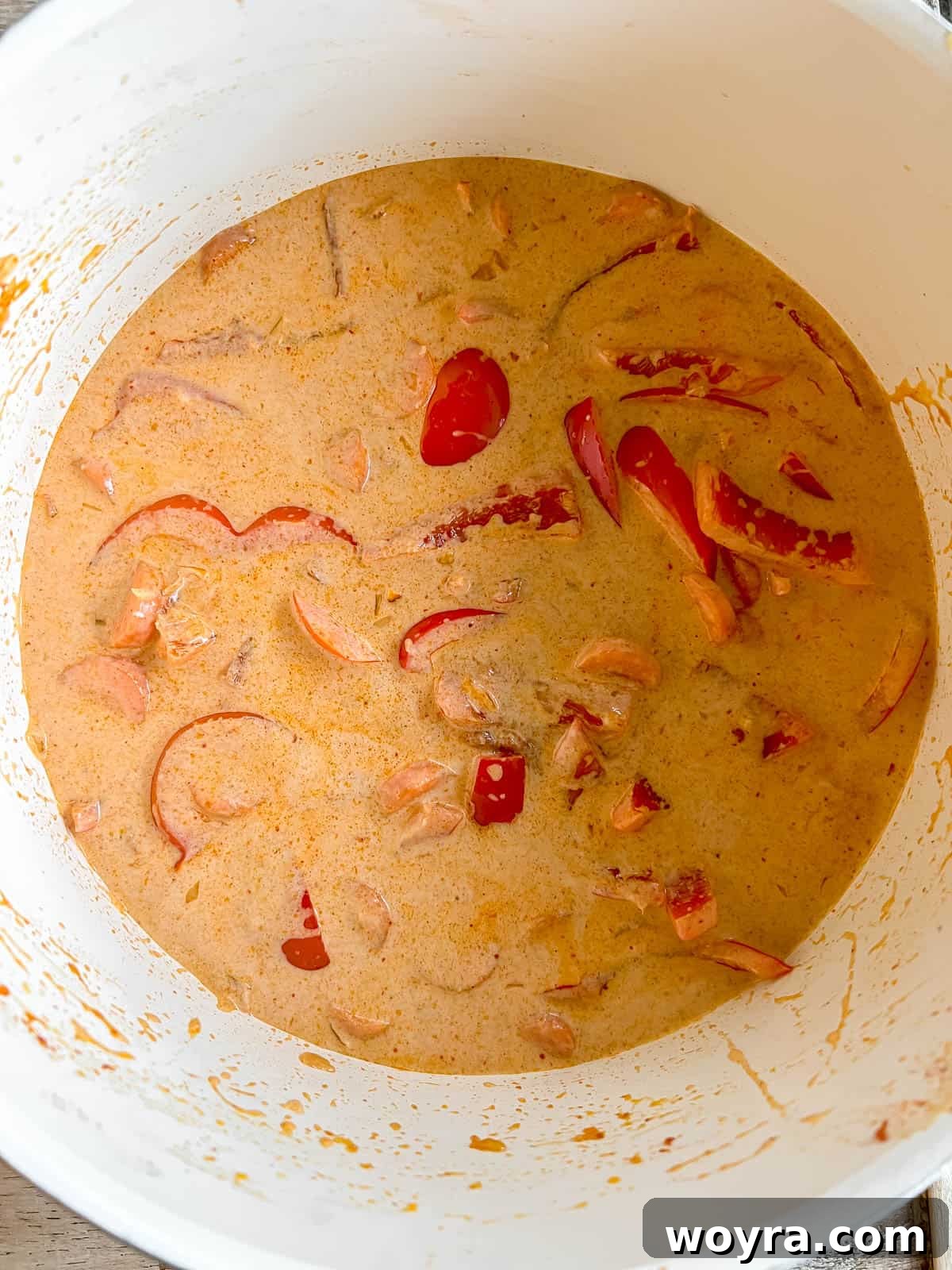 Plant-Based Paleo Thai Red Curry 7 Pouring rich coconut cream into the pan with the curry base.
