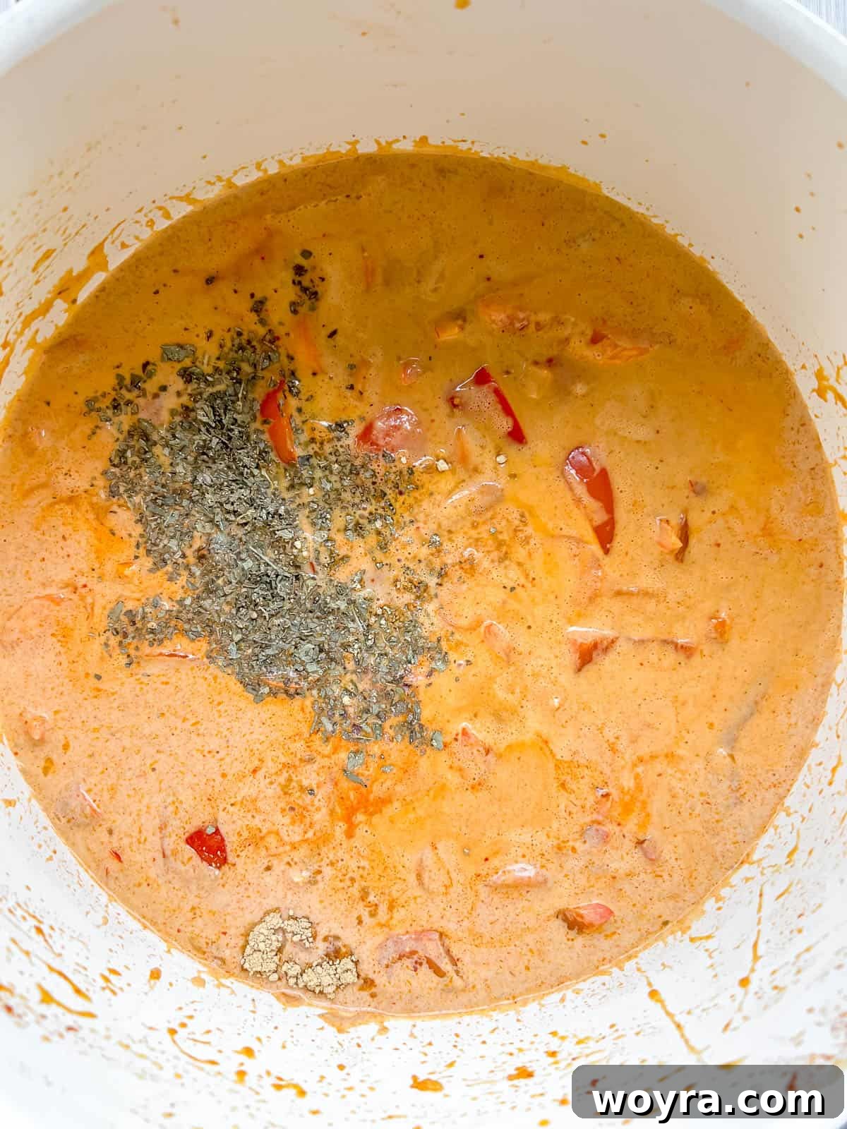 Plant-Based Paleo Thai Red Curry 8 Adding lime juice, maple syrup, water, salt, dried basil, ground ginger, and coconut aminos to the curry.