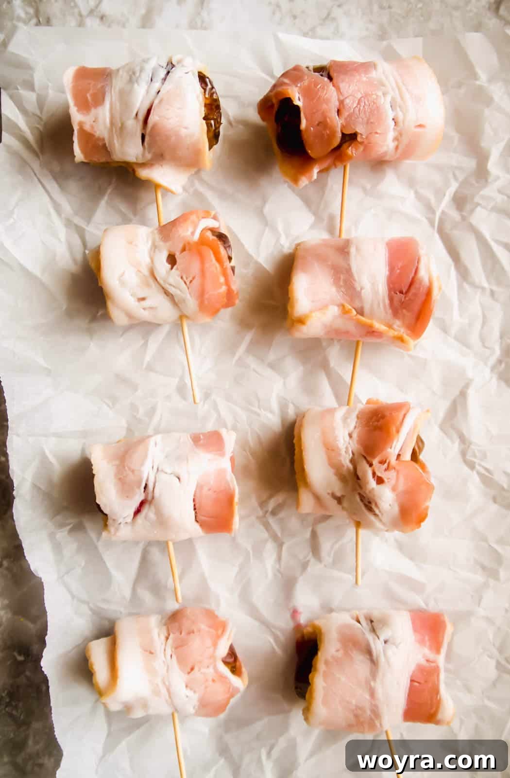 Crispy Bacon-Wrapped Raspberry Stuffed Dates 7 Raw bacon wrapping the raspberry stuffed dates before cooking.