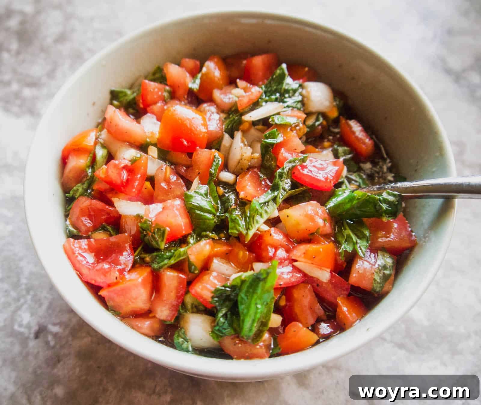 A bowl containing the freshly mixed bruschetta topping ingredients.
