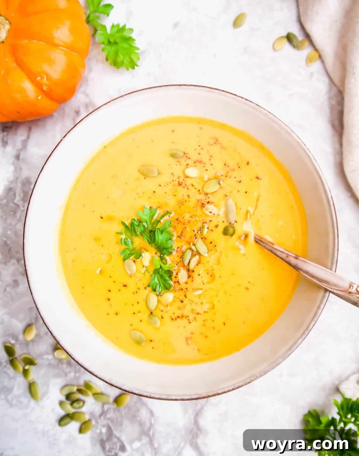 A close-up shot of creamy pumpkin sweet potato soup in a bowl, showcasing its rich texture and inviting warmth, garnished with subtle hints of flavor.