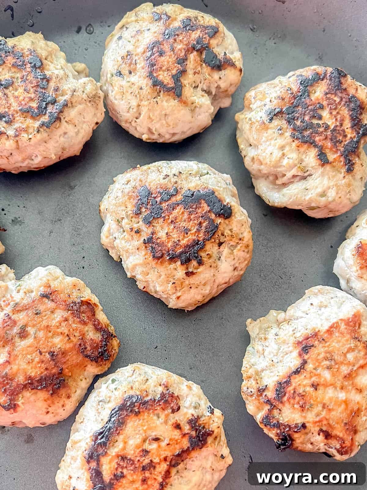 Clean Turkey Sausage Patties (Paleo and Whole30) 7 Freshly cooked turkey sausage patties in a pan, ready to be plated.