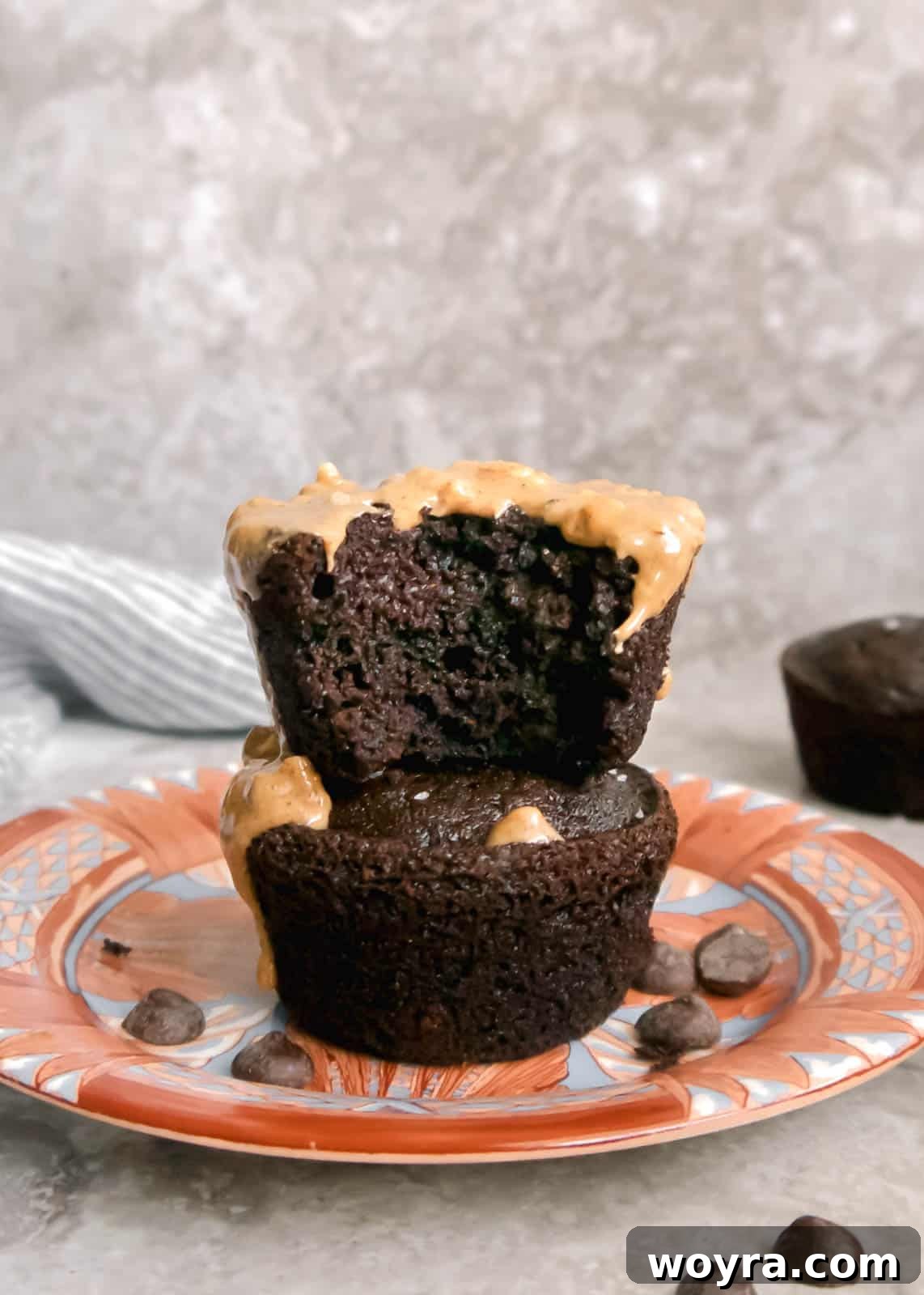 Decadent Paleo Chocolate Muffins 11 Stack of gluten-free double chocolate muffins, with a bite taken out of the top one.