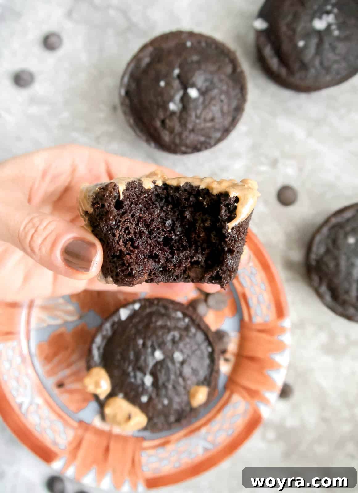 Decadent Paleo Chocolate Muffins 3 Almond flour chocolate muffin with a bite taken out, showing its moist texture.