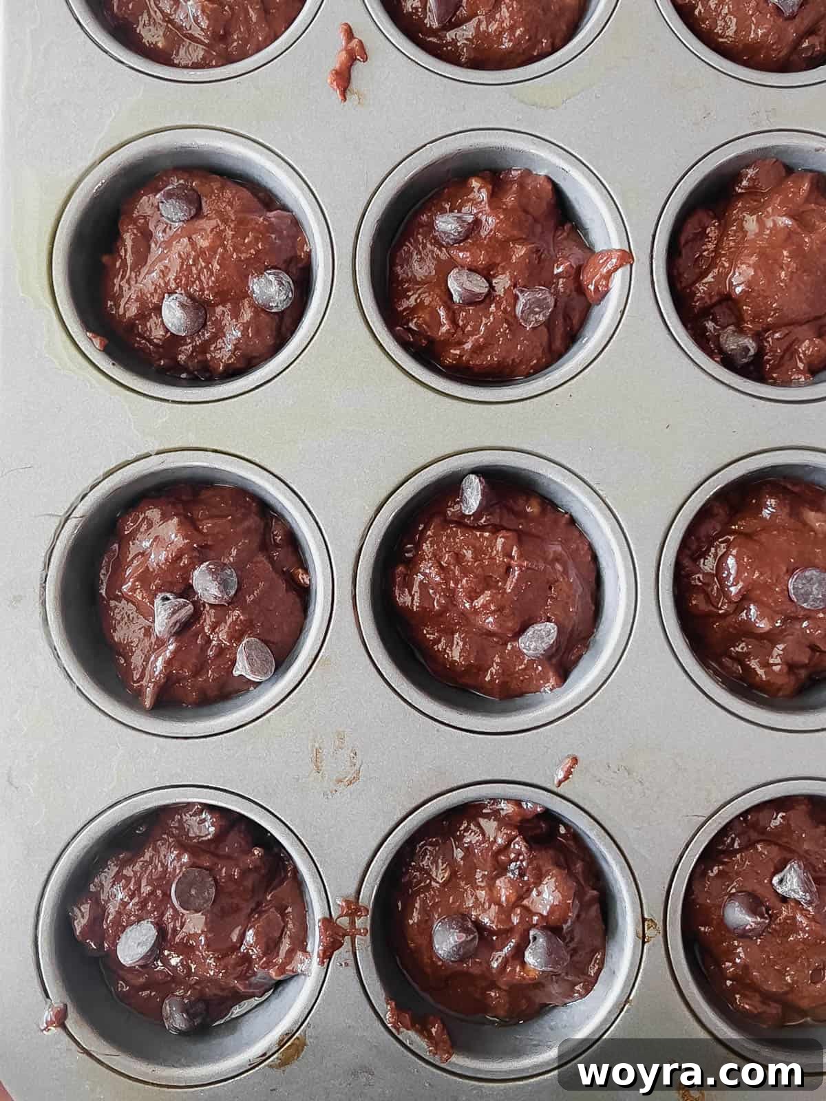 Decadent Paleo Chocolate Muffins 9 Paleo chocolate muffin batter scooped into greased muffin tins before baking.
