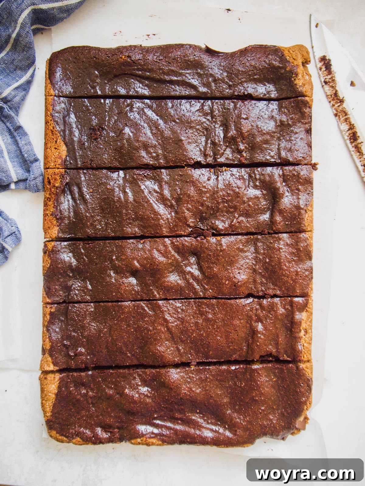 A knife gently cutting into the baked paleo brownie cookie bars.