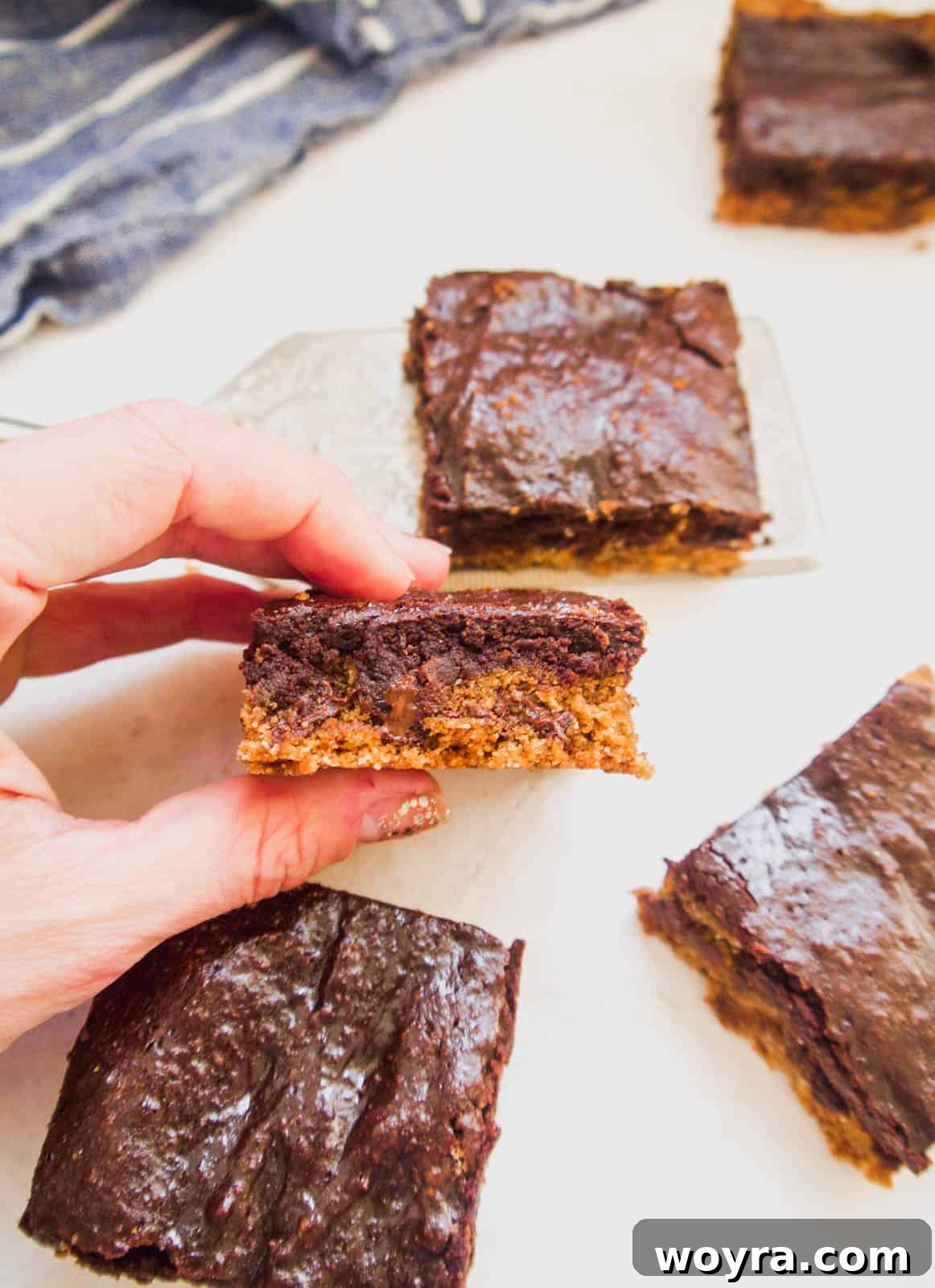 A close-up shot of a perfectly cut slice of a healthy brookie recipe, showing its distinct cookie and brownie layers.