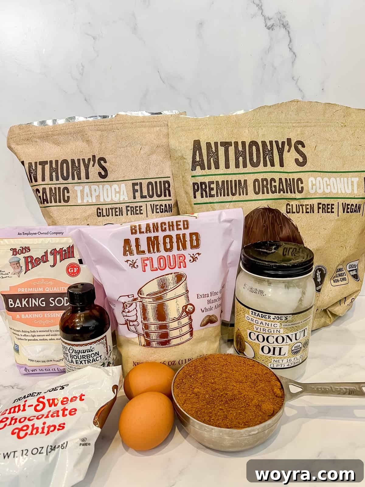 A flat lay photograph displaying all the dry and wet ingredients neatly arranged for the cookie layer of gluten-free brookies.