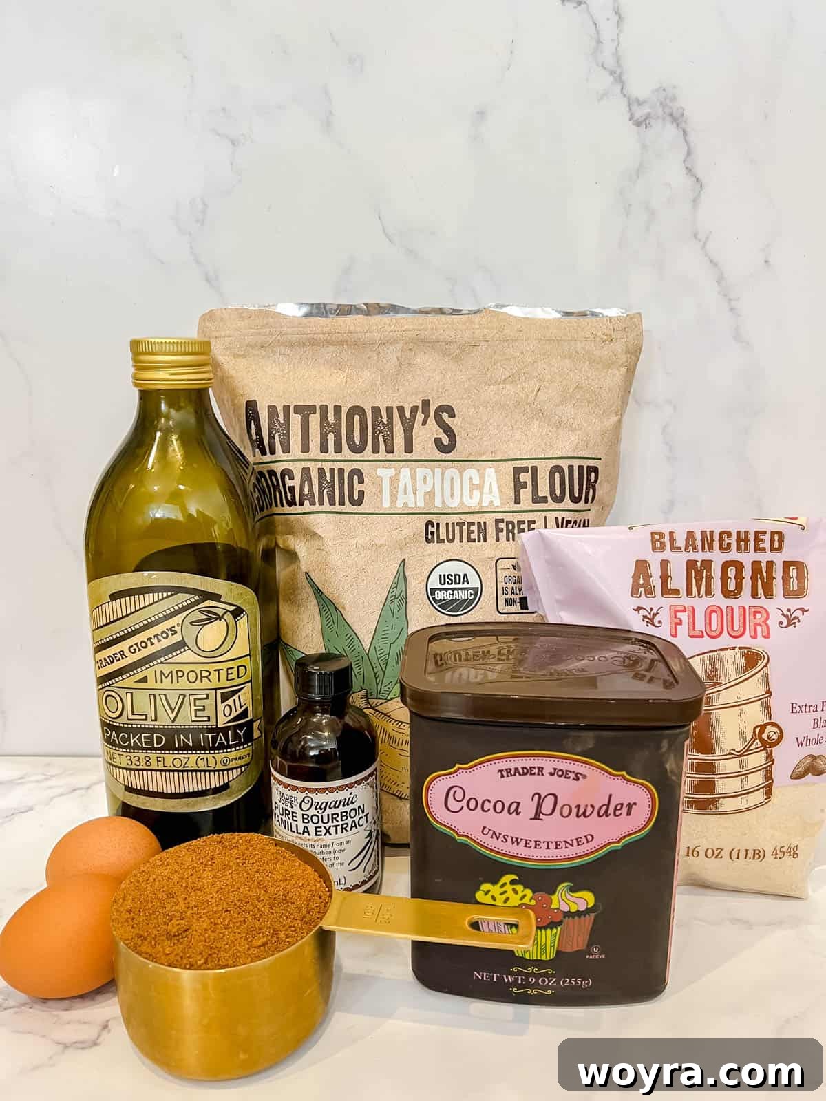 A flat lay photograph displaying all the dry and wet ingredients neatly arranged for the brownie layer of gluten-free brookies.