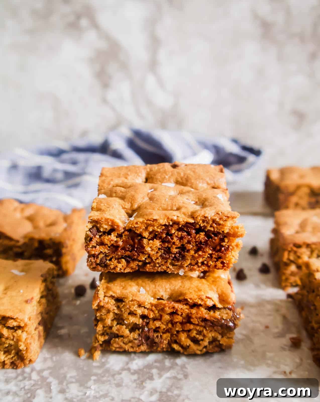 Primal Chocolate Chip Cookie Bars 2 Stacked gluten-free chocolate chip cookie bars with visible chocolate chips, showcasing their soft, chewy texture.