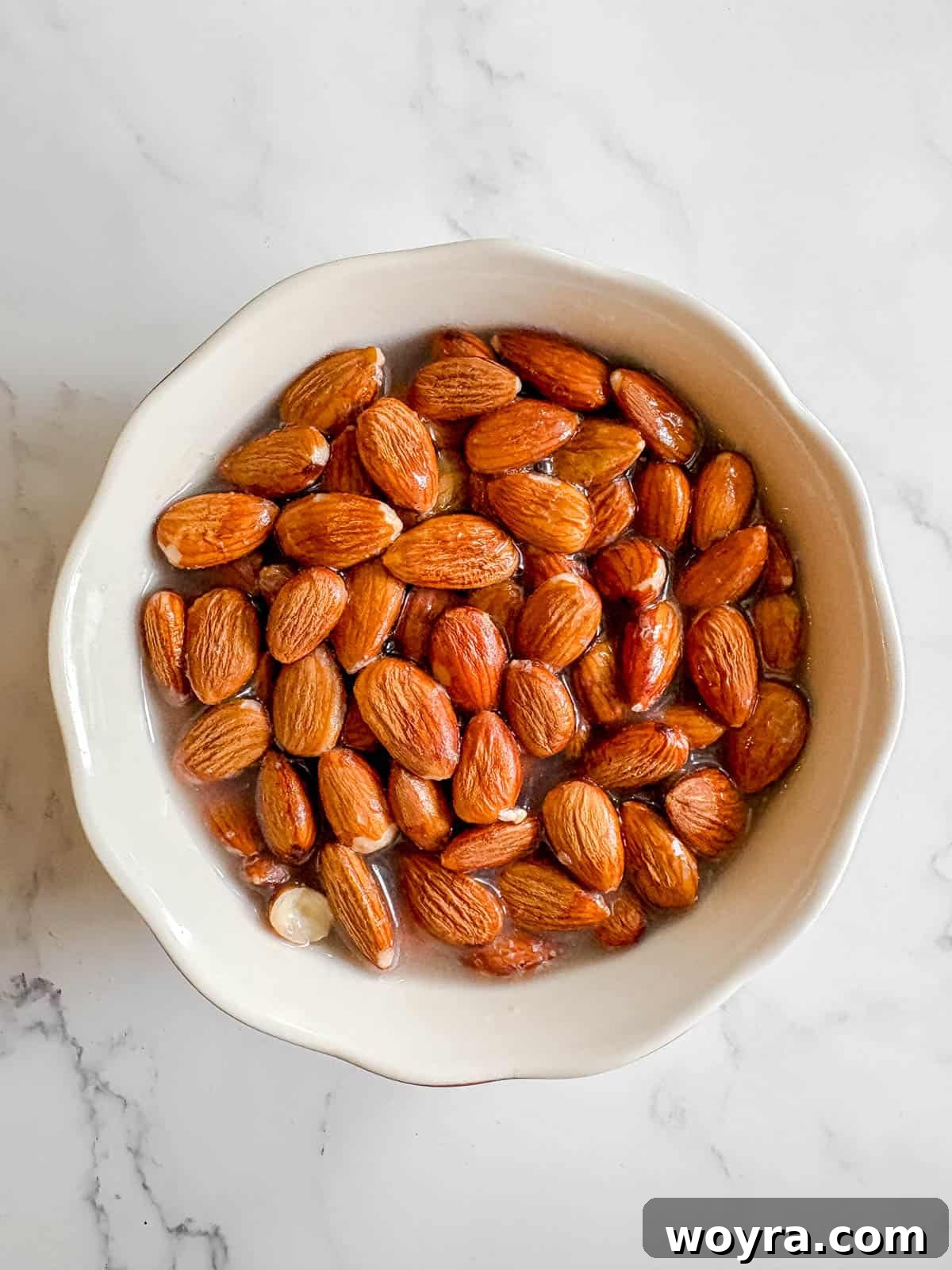 Homemade Strawberry Almond Milk: A Vegan Delight 3 Raw almonds soaking in a clear bowl of water, typically left overnight to soften and prepare for blending.