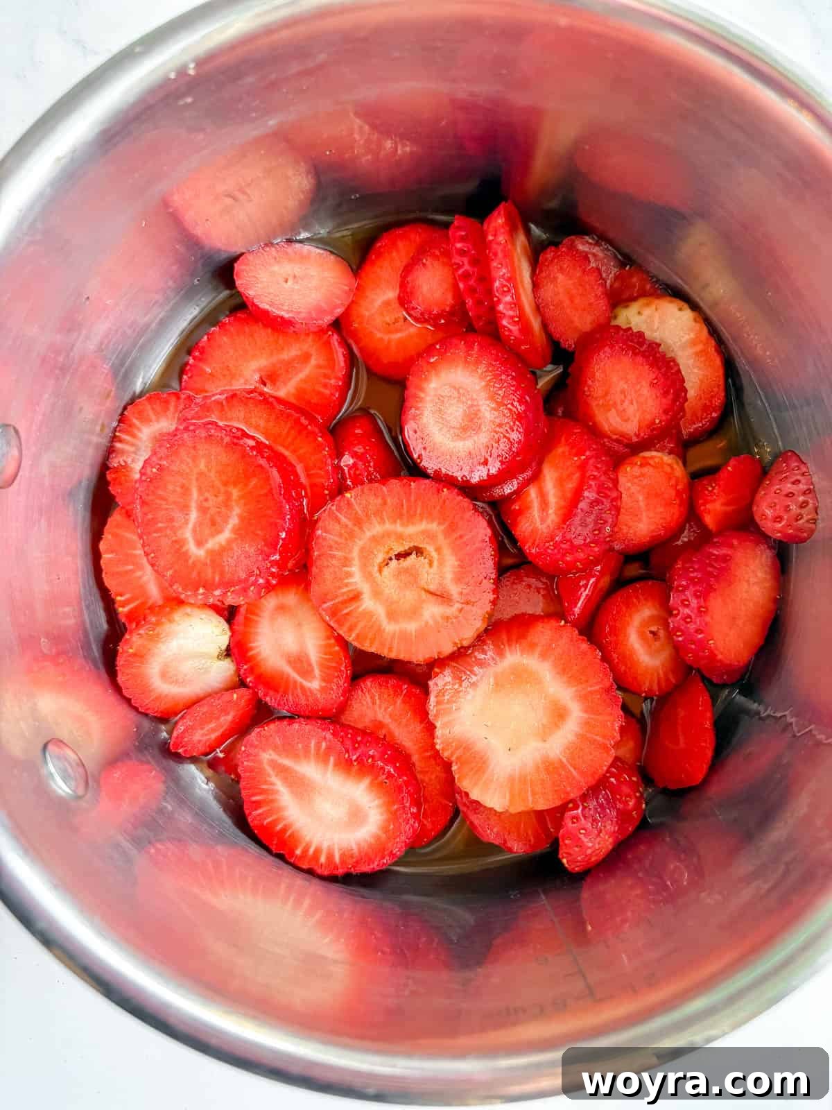 Homemade Strawberry Almond Milk: A Vegan Delight 4 Sliced fresh strawberries, maple syrup, vanilla extract, and a small amount of water combined in a saucepan, ready to be heated and transformed into a delicious syrup.
