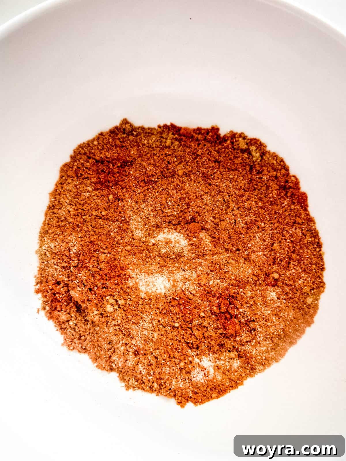 Tender Apple-Infused Pulled Pork 4 A small bowl containing a mix of onion powder, garlic powder, cinnamon, paprika, and rubbed sage, ready to season the pork.