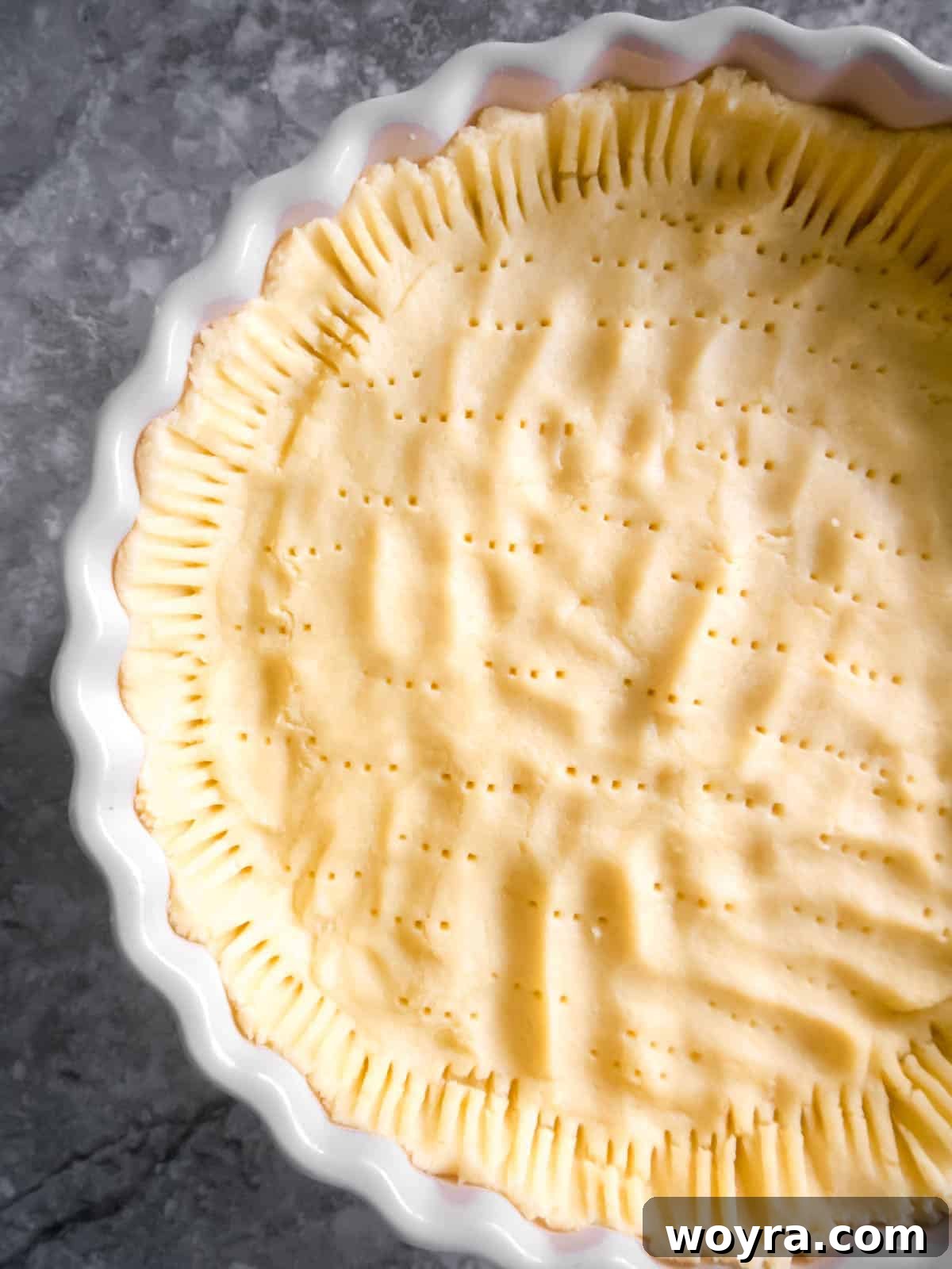 Ancestral Apple Indulgence 6 Raw tart dough spread evenly into a tart pan, with edges pressed against the sides.