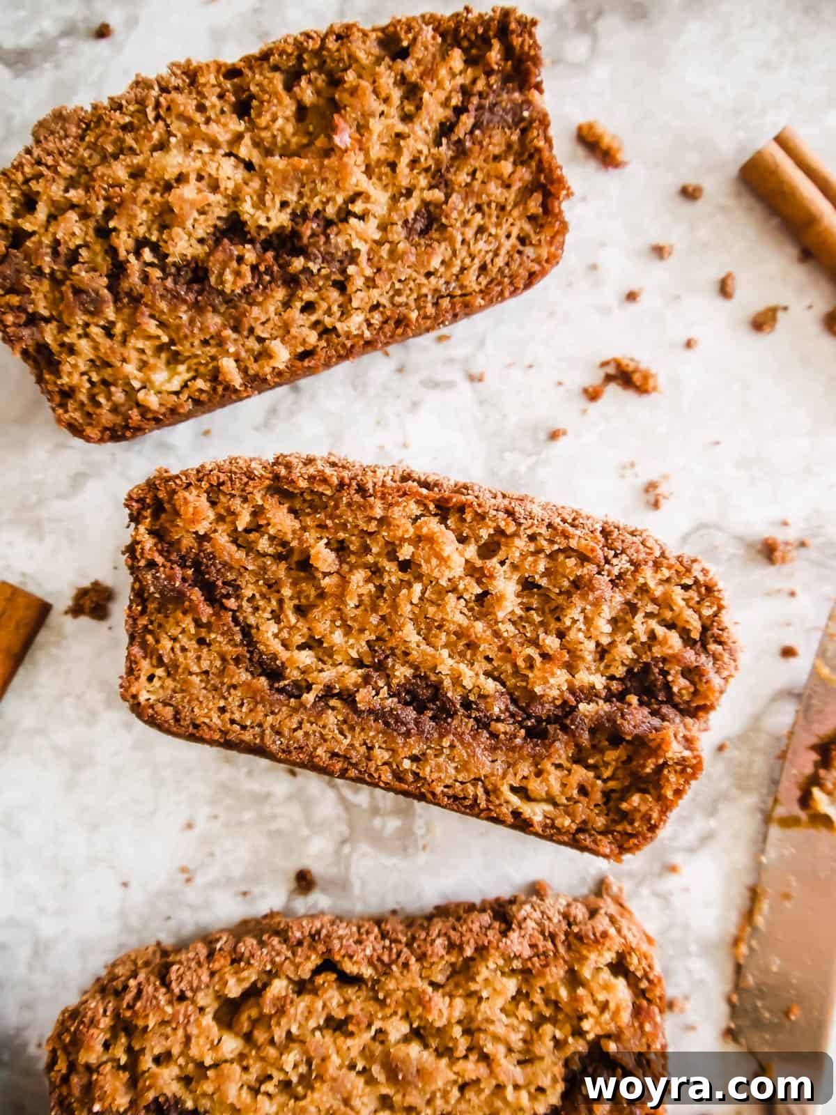 A perfectly sliced piece of paleo coffee cake banana bread on a rustic wooden table.