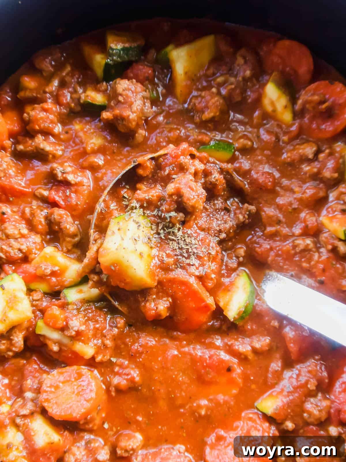 Healthy Meat Sauce with Carrots and Zucchini simmering in a large pot on the stovetop.