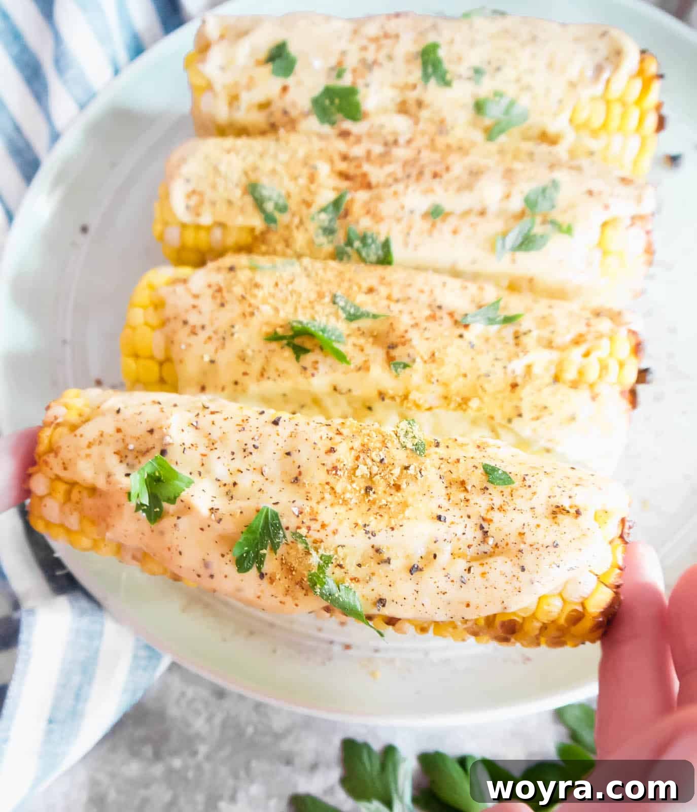 Plant-Based Mexican Street Corn 9 Dairy-free street corn held in hands, showing the creamy sauce and garnishes.