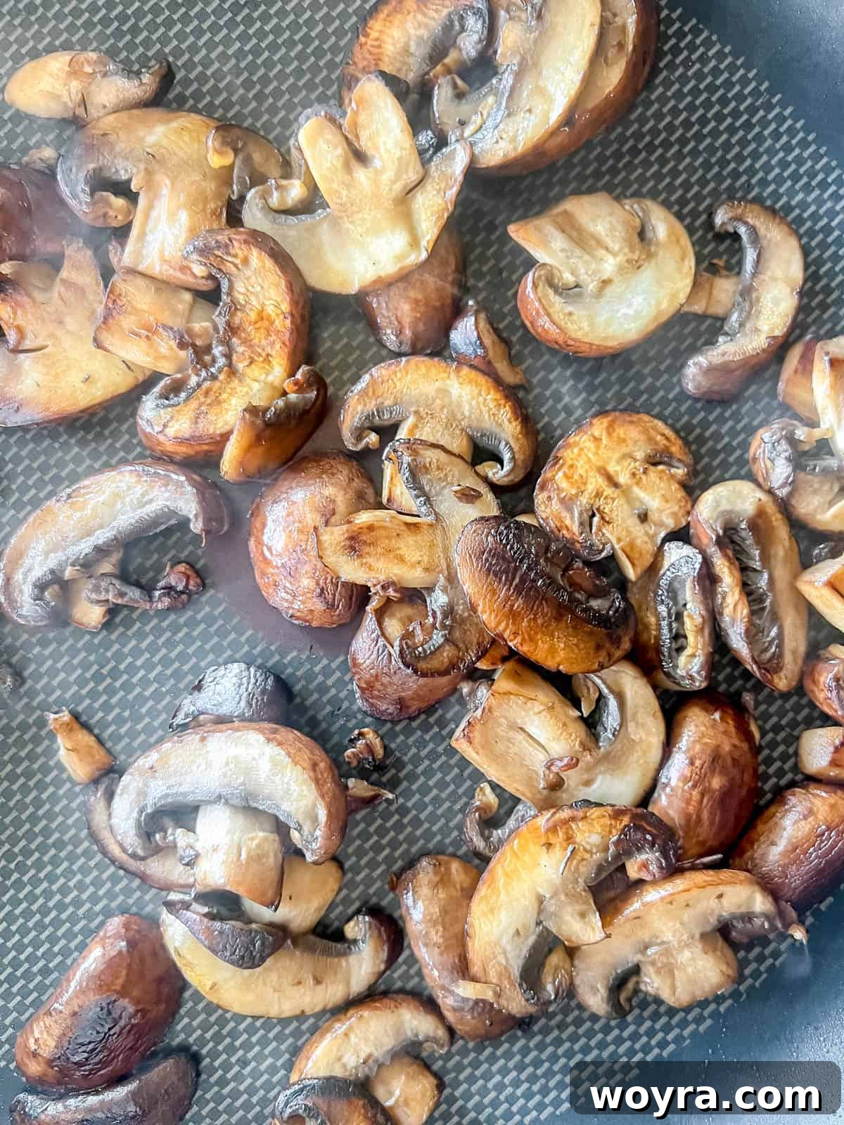 Grilled mushrooms sizzling in a pan.