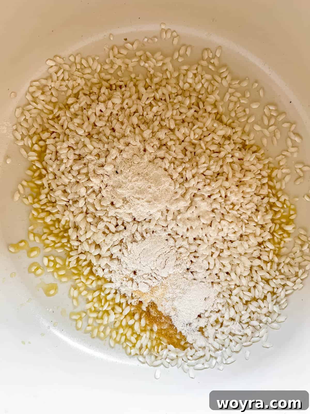 Arborio rice cooking in a pot with seasonings.