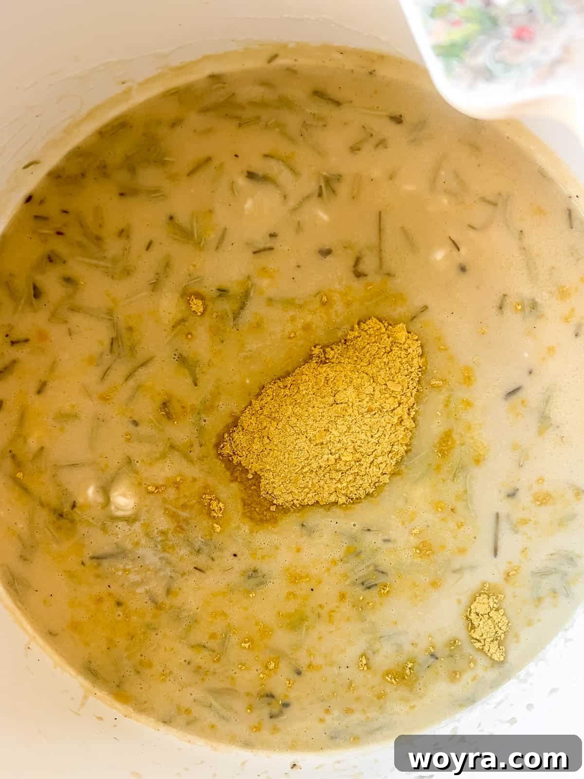 More broth and nutritional yeast being mixed into the risotto.