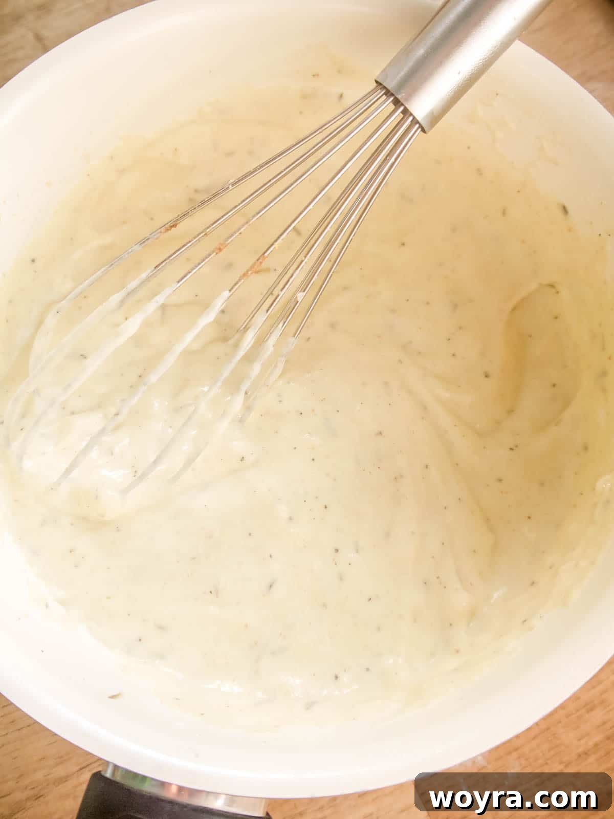 The finished creamy vegan sauce for cauliflower gratin, thick and smooth in the pan.
