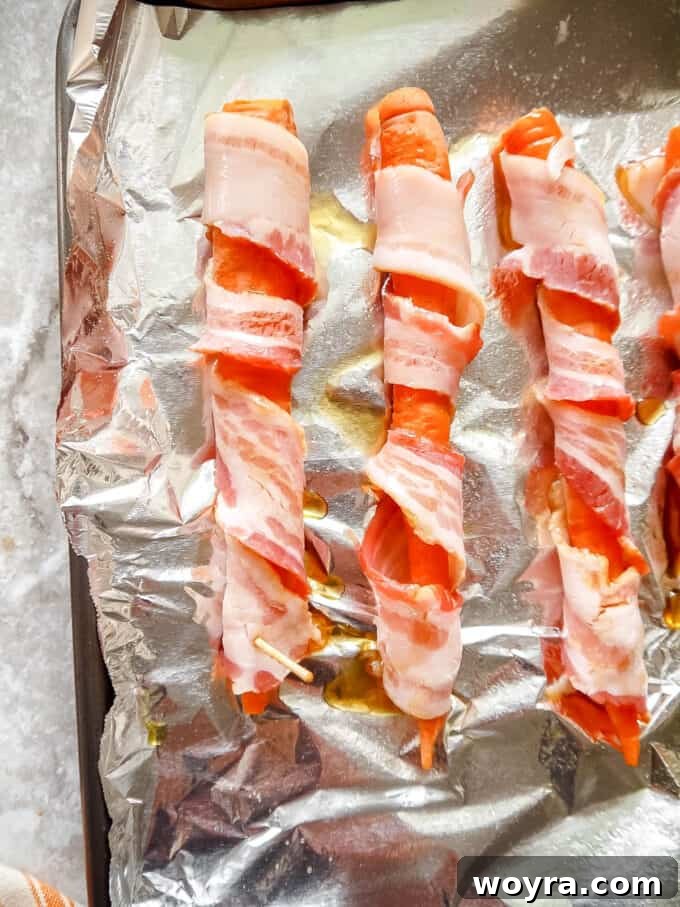 Paleo Gluten Free Maple Bacon Roasted Carrots 6 Visual guide: Mid-way through wrapping a carrot with bacon for even coverage.