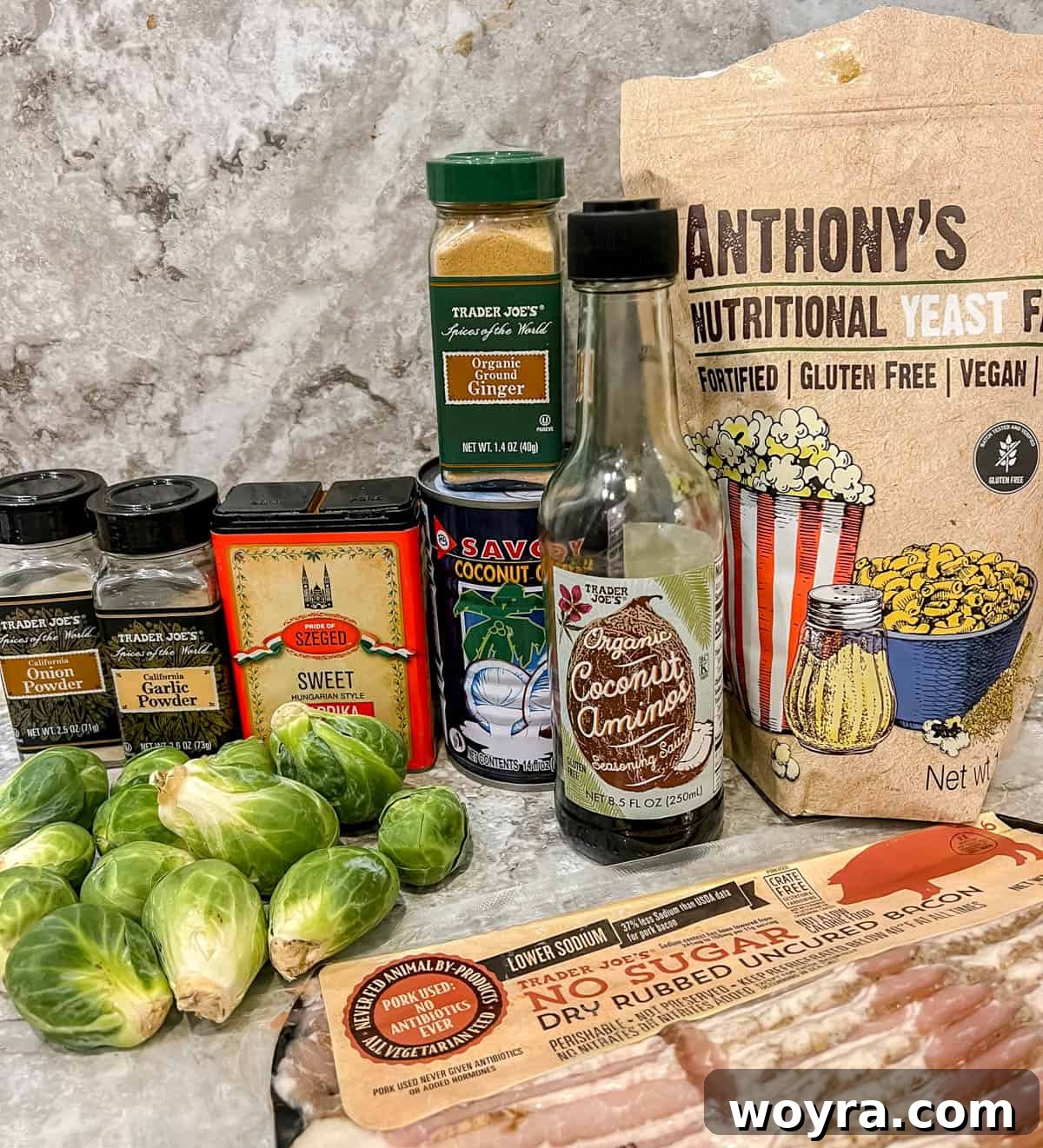 Paleo Whole30 Dairy Free Brussels Sprouts Casserole 4 A flat lay photograph showcasing all the fresh ingredients laid out for making the dairy free Brussels sprouts casserole, including sprouts, bacon, and various spices.