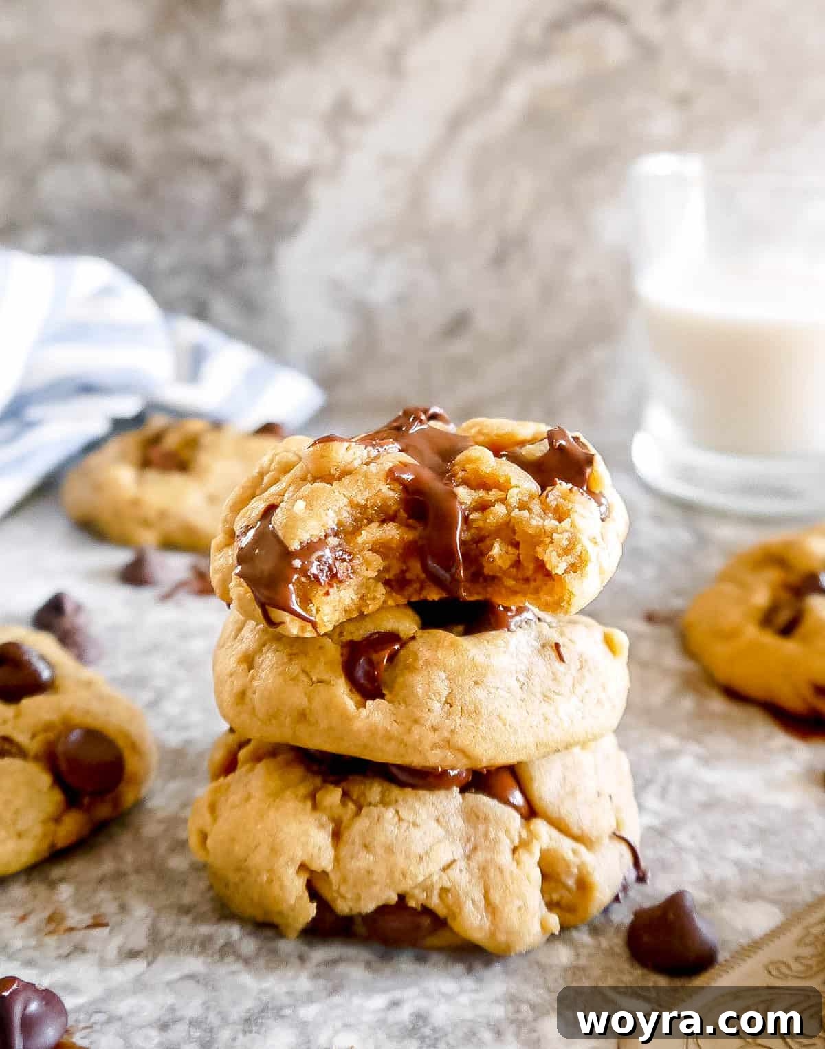 Mediterranean Chocolate Chip Jewels 9 Three perfectly baked olive oil chocolate chip cookies stacked elegantly, with the top cookie showcasing a bite taken out.