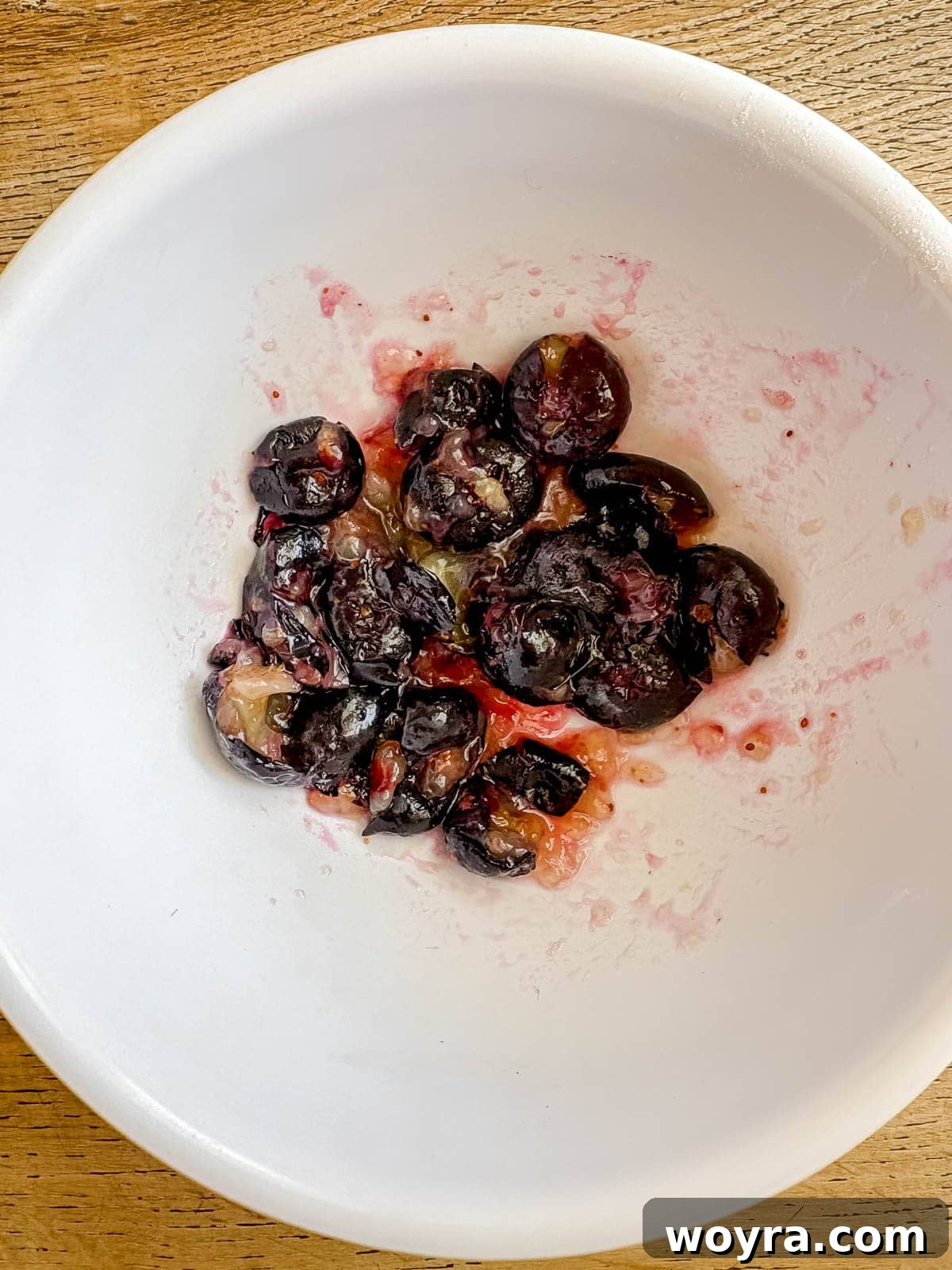 Dairy Free Olive Oil Blueberry Muffins 7 Some blueberries mashed in a bowl for the muffin batter.