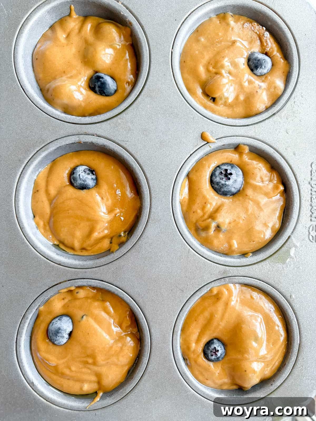 Dairy Free Olive Oil Blueberry Muffins 9 Muffin batter divided into greased muffin tins before baking.