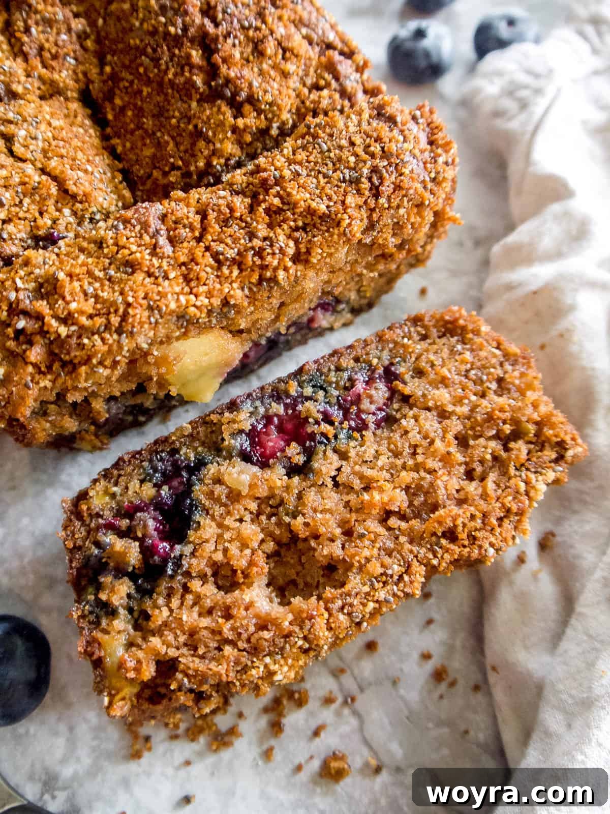 Guilt-Free Paleo Gluten-Free Apple Blueberry Loaf 3 A perfectly baked slice of almond flour apple bread resting on a rustic wooden table.