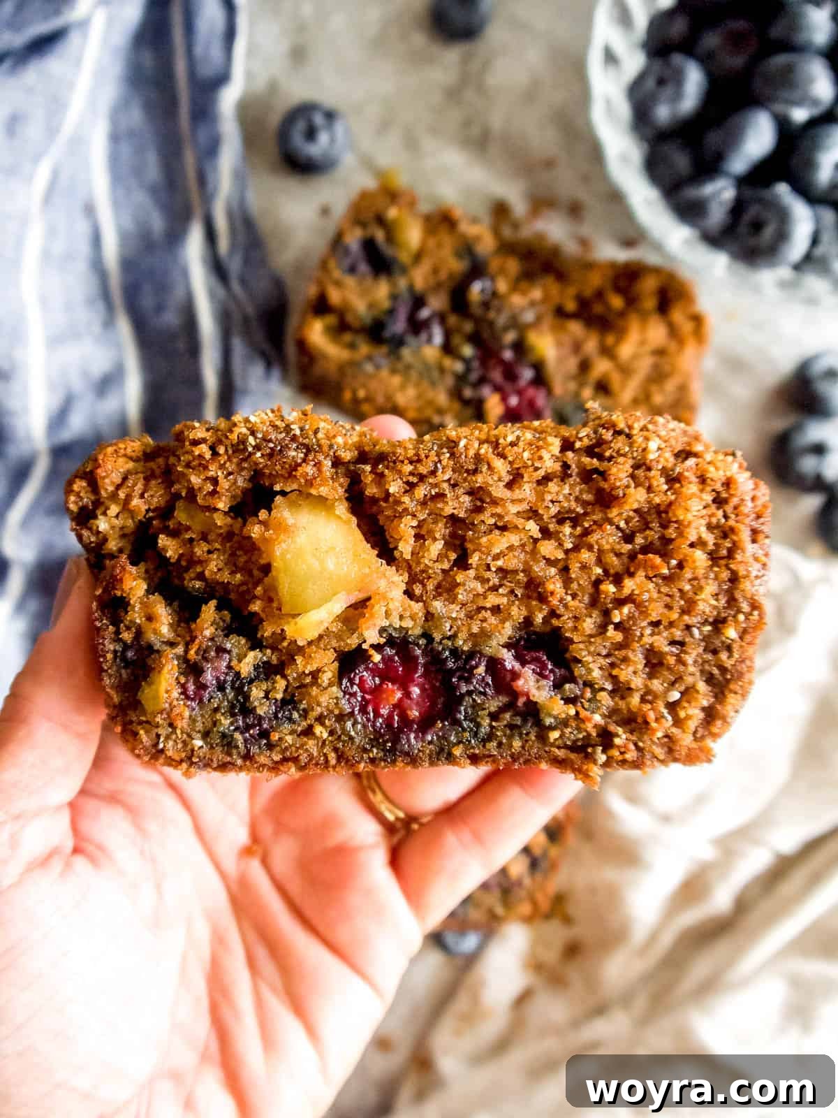 Guilt-Free Paleo Gluten-Free Apple Blueberry Loaf 6 A delicious slice of almond flour blueberry bread being held, ready to be enjoyed.