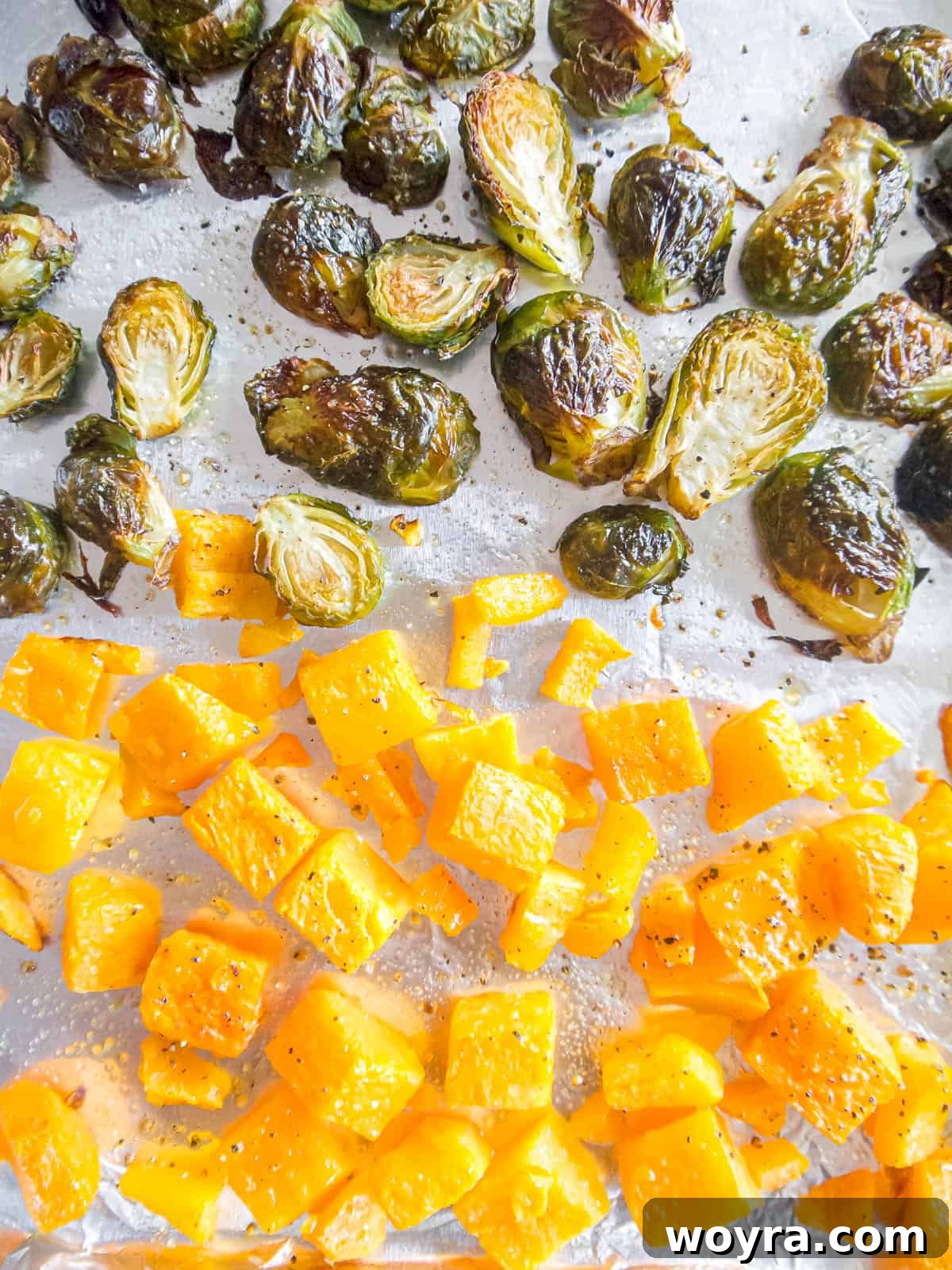 Maple Glazed Harvest Salad 5 Cubed butternut squash and halved Brussels sprouts evenly spread on a baking sheet, seasoned and ready for roasting.
