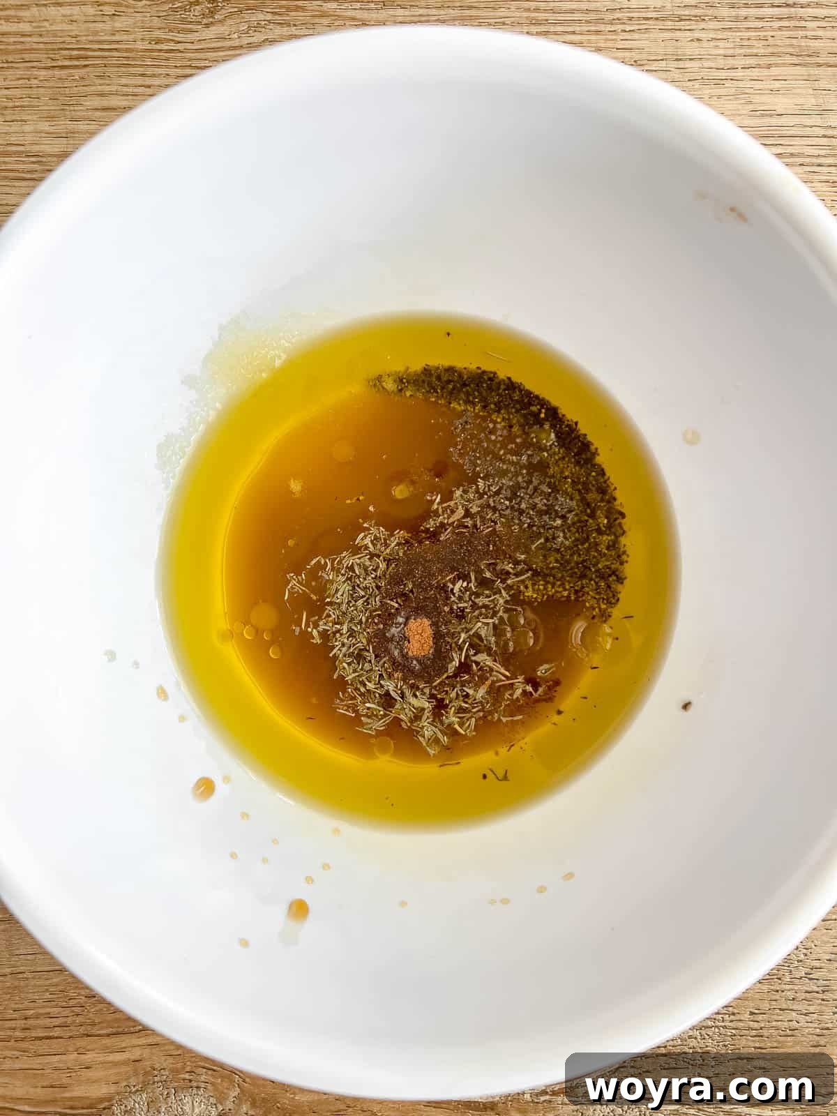 Maple Glazed Harvest Salad 6 Homemade maple vinaigrette dressing vigorously whisked in a small glass bowl, showing its creamy texture.