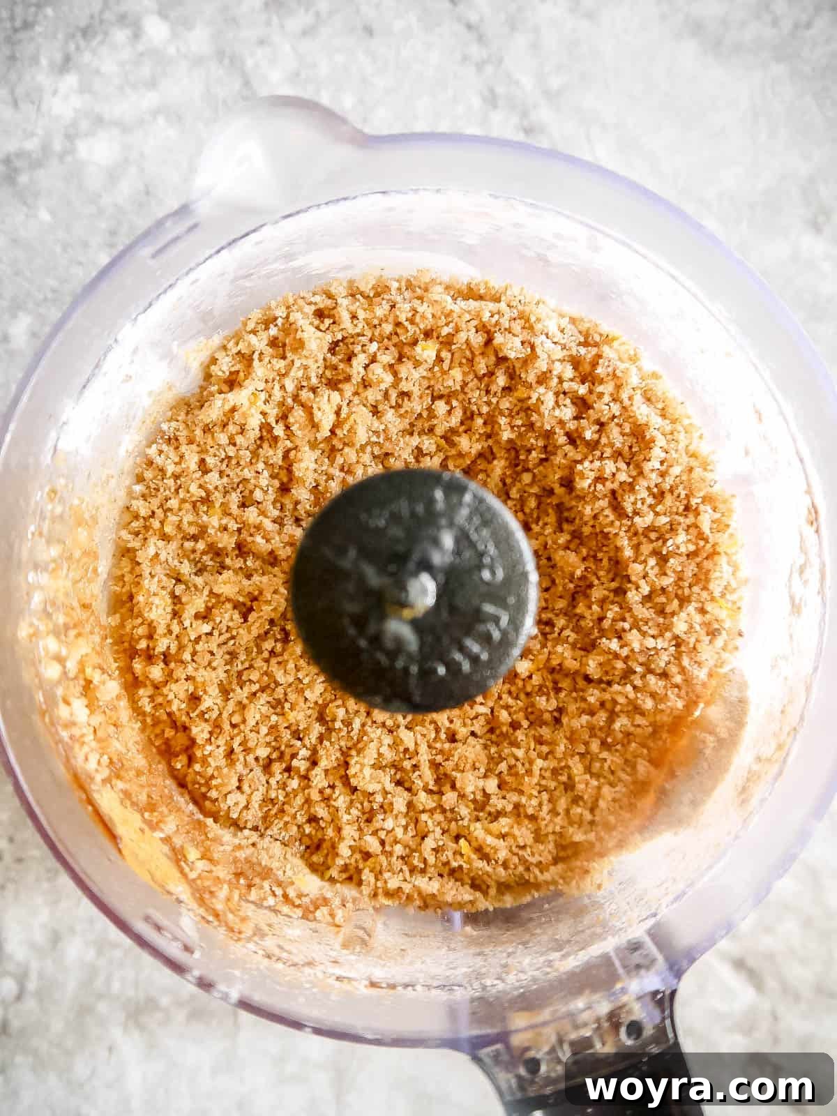 Lemon zest streusel crumb topping mixture in a food processor, showing a coarse, crumbly texture.
