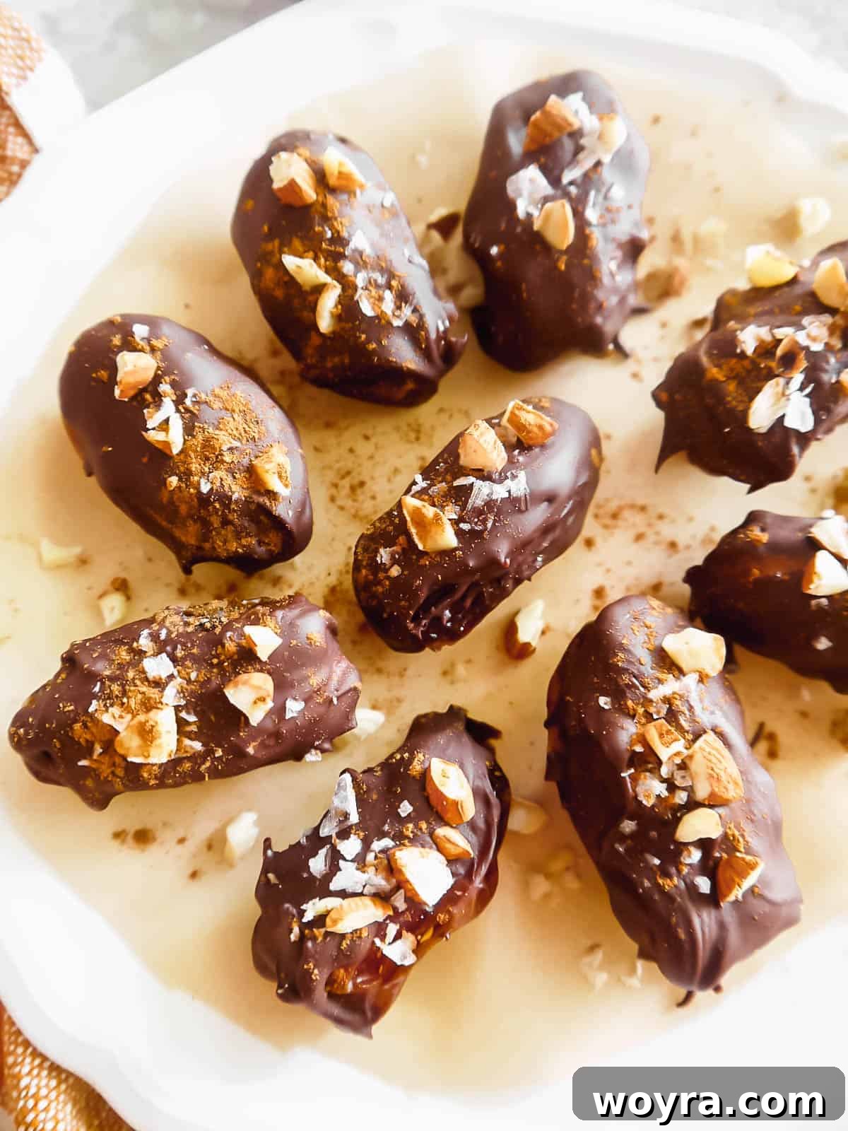 Autumn Spiced Chocolate Pumpkin Dates 2 Delicious Chocolate Covered Pumpkin Stuffed Dates arranged beautifully on a plate, ready to be enjoyed.